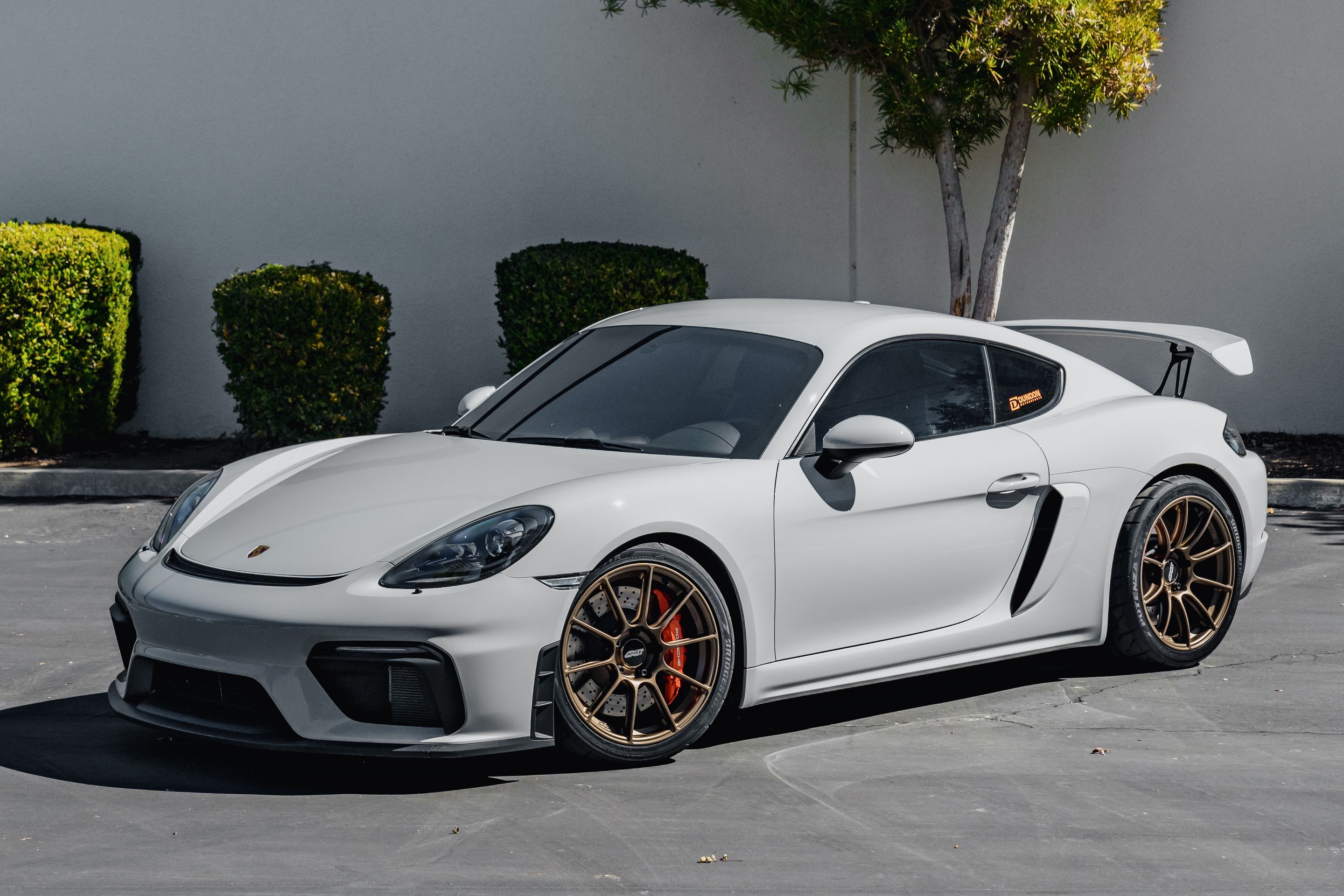 Grey Porsche 718 Cayman GT4 with 19" SM-10RS Apex wheels in Satin Bronze