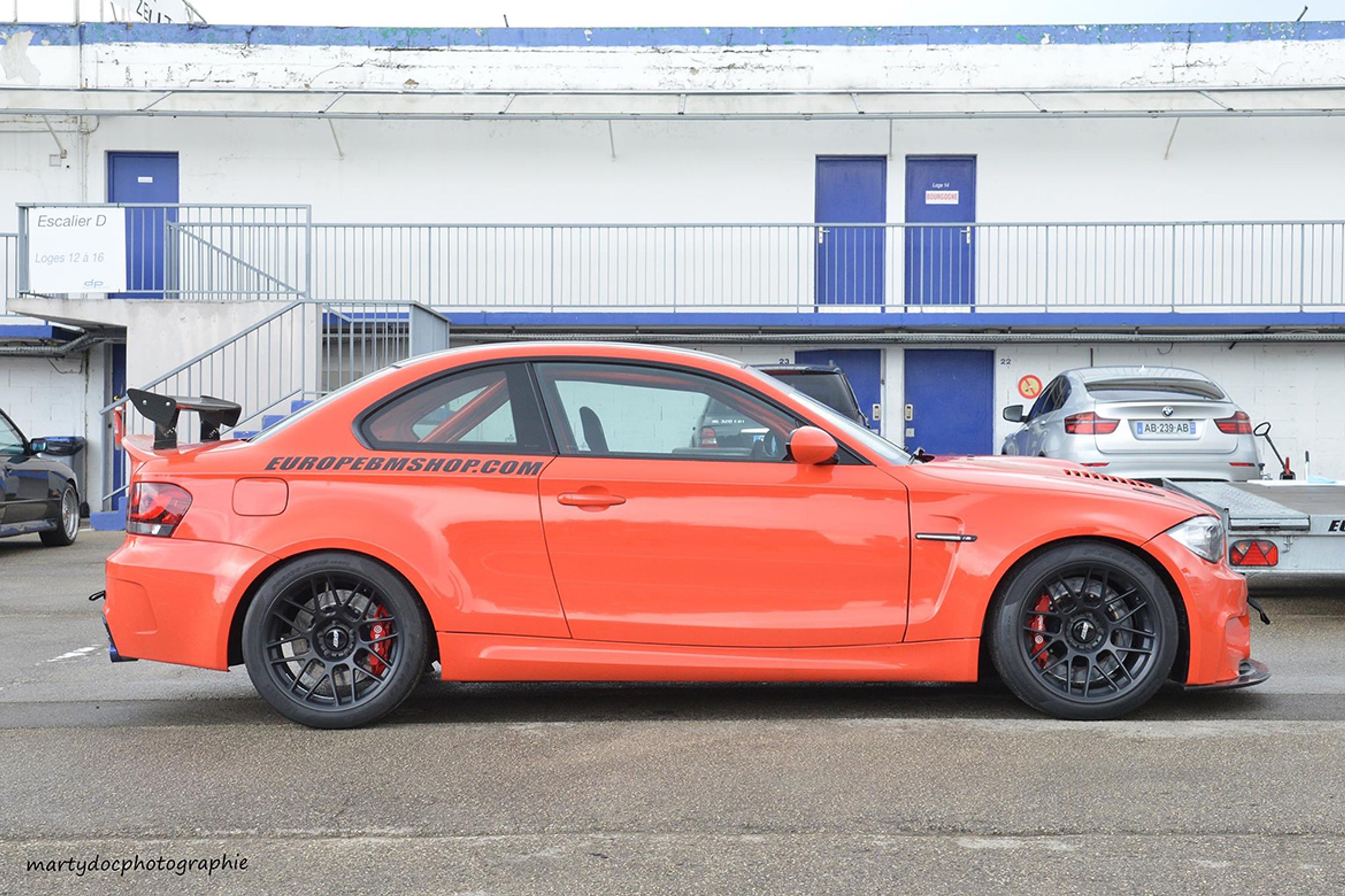 Orange BMW E82 1M with 18" ARC-8 Apex wheels in Satin Black