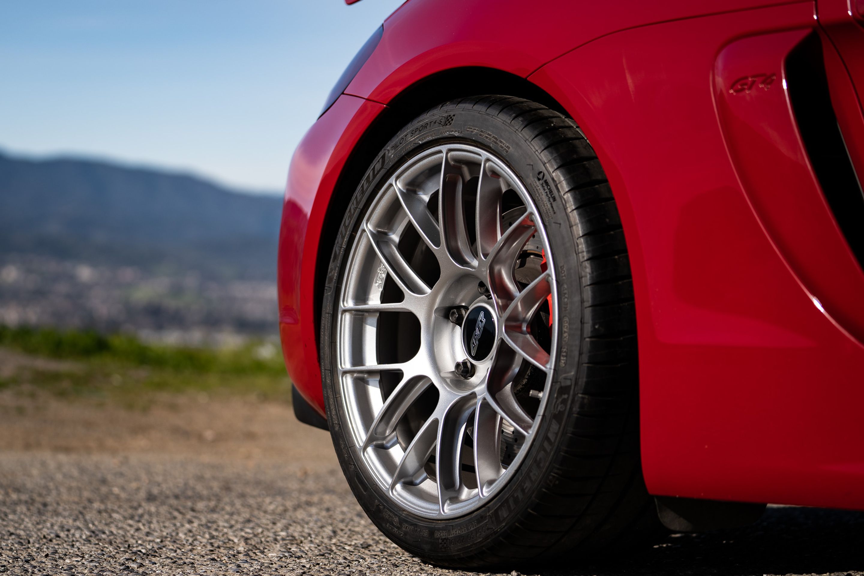 Red Porsche 981 Cayman GT4 with 19" EC-7RS Apex wheels in Race Silver