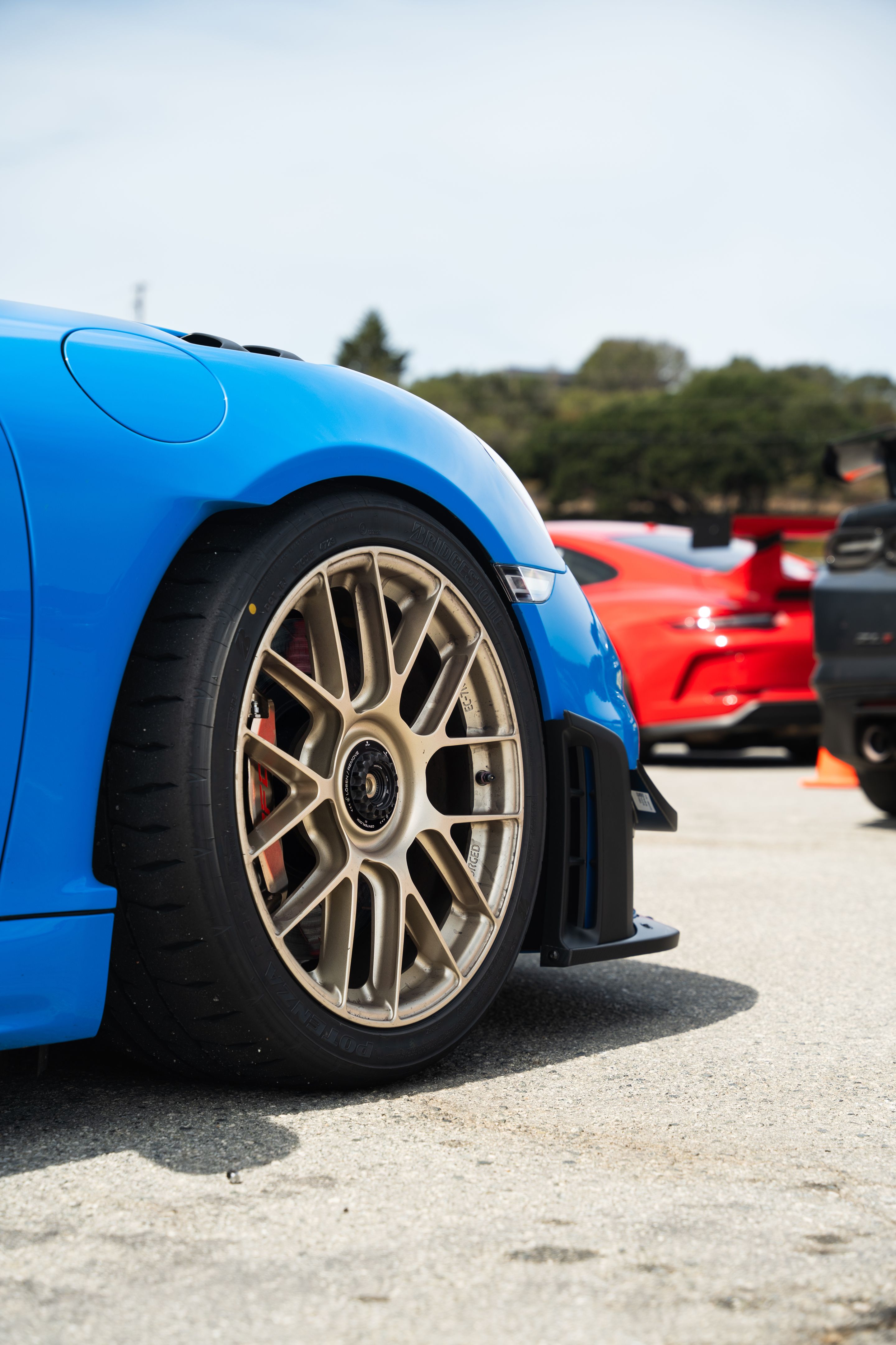 Blue Porsche 718 Cayman GT4 RS with 19" EC-7RS Apex wheels in Motorsport Gold