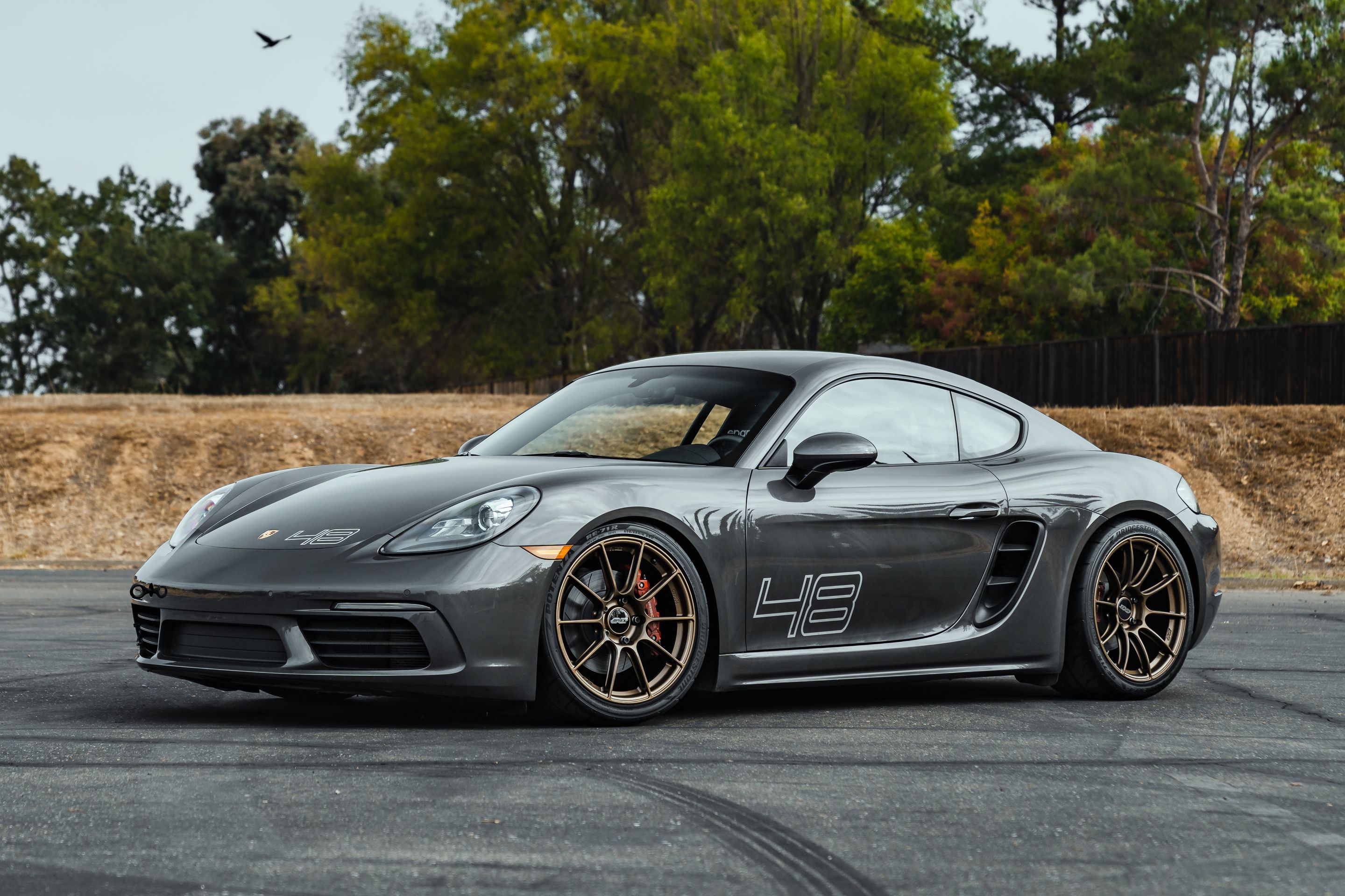 Grey Porsche 718 Cayman S with 19" SM-10RS Apex wheels in Satin Bronze