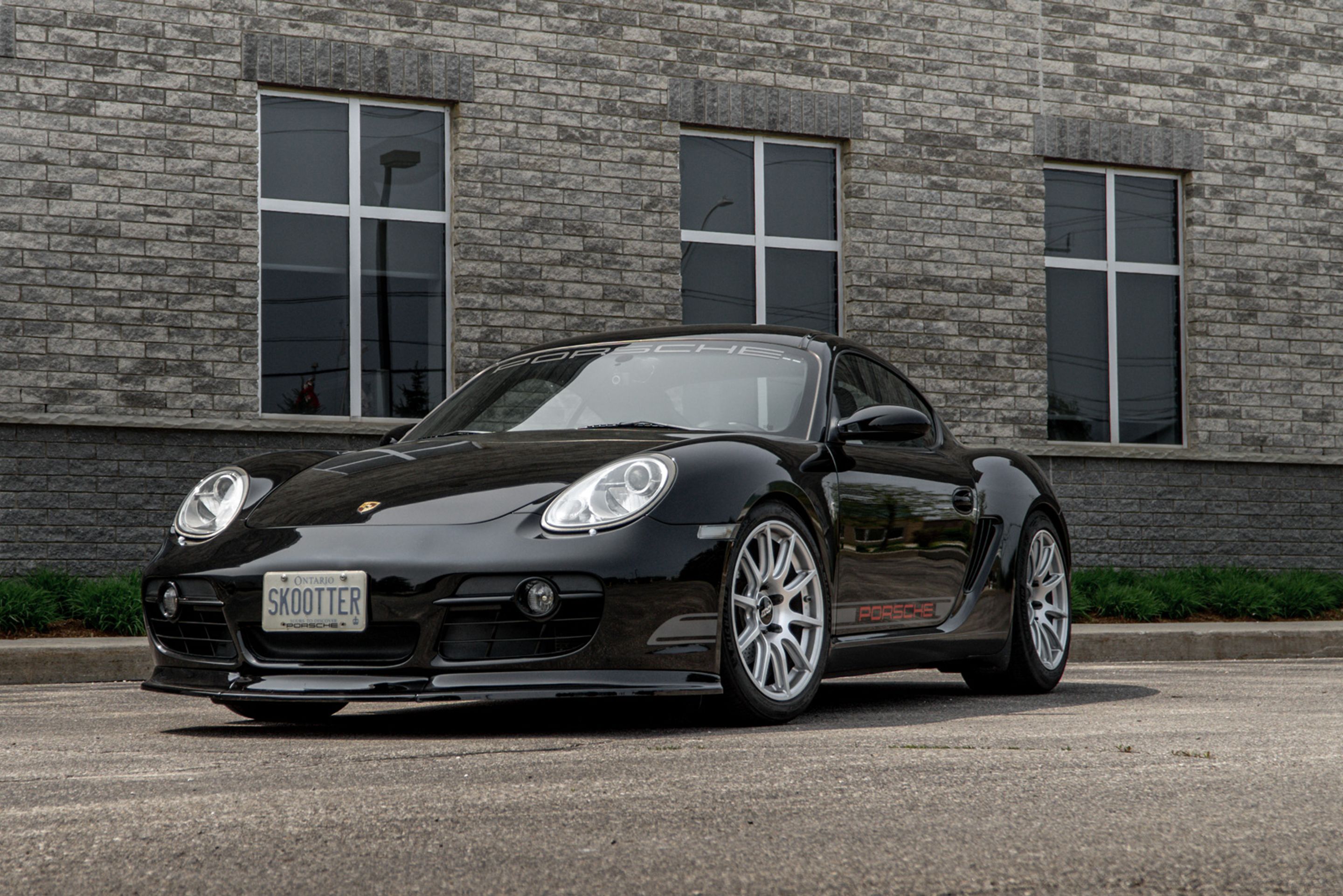 Black Porsche 987 Cayman Base with 18" SM-10 Apex wheels in Race Silver