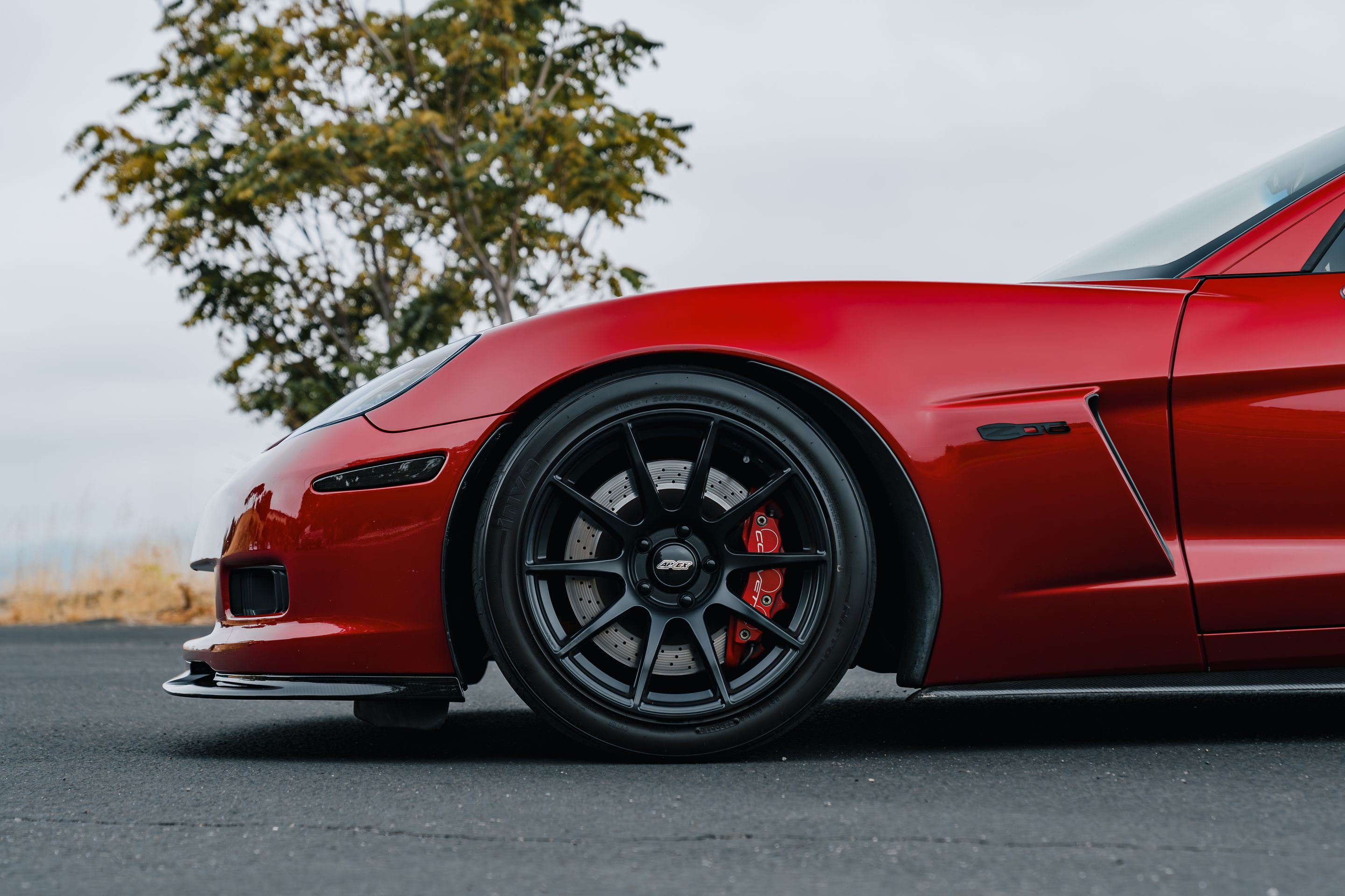 Red Chevrolet C6 Corvette Z06 with 18"/19" SM-10 Apex wheels in Satin Black