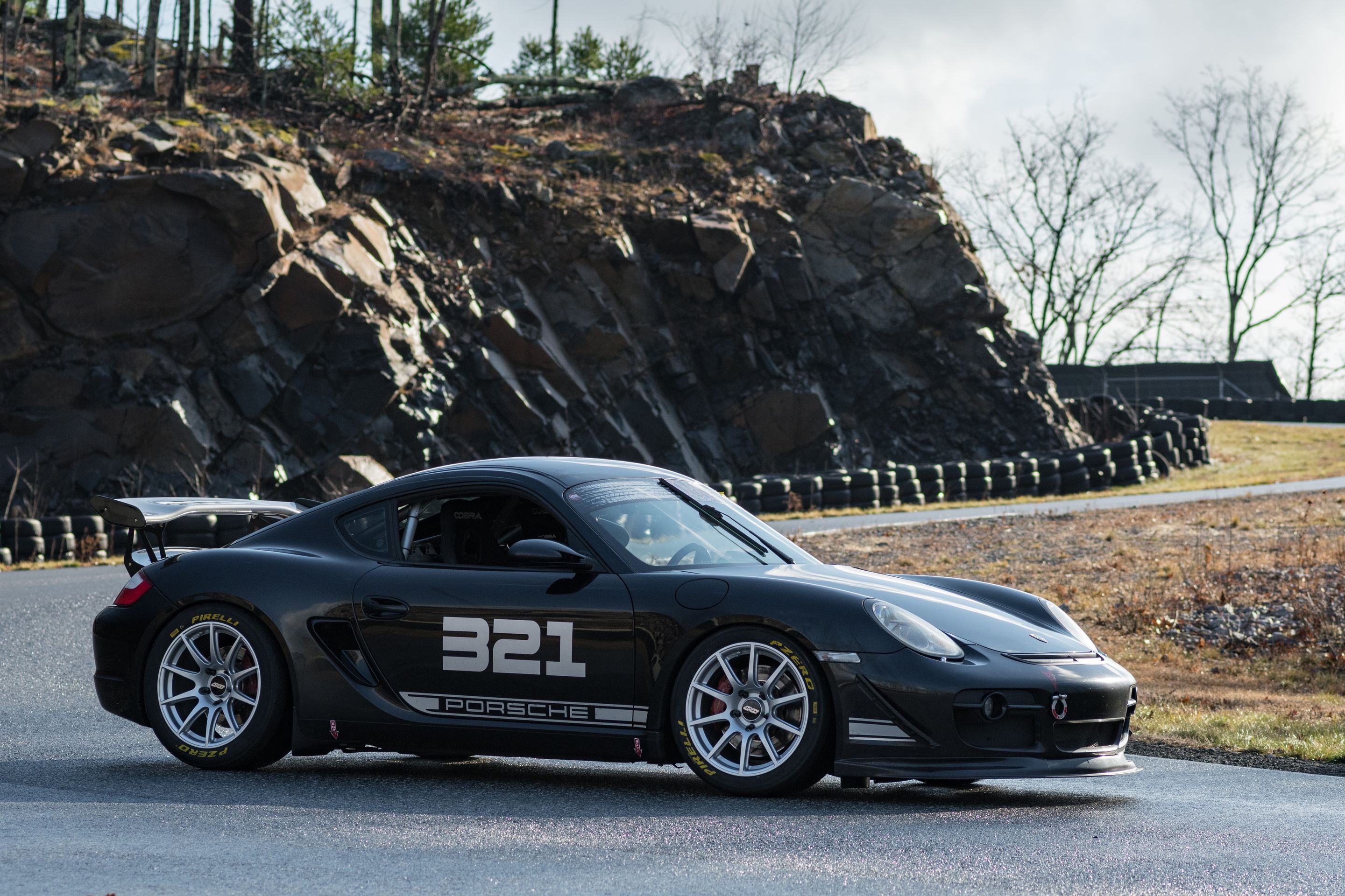 Black Porsche 987 Cayman S with 18" SM-10 Apex wheels in Race Silver