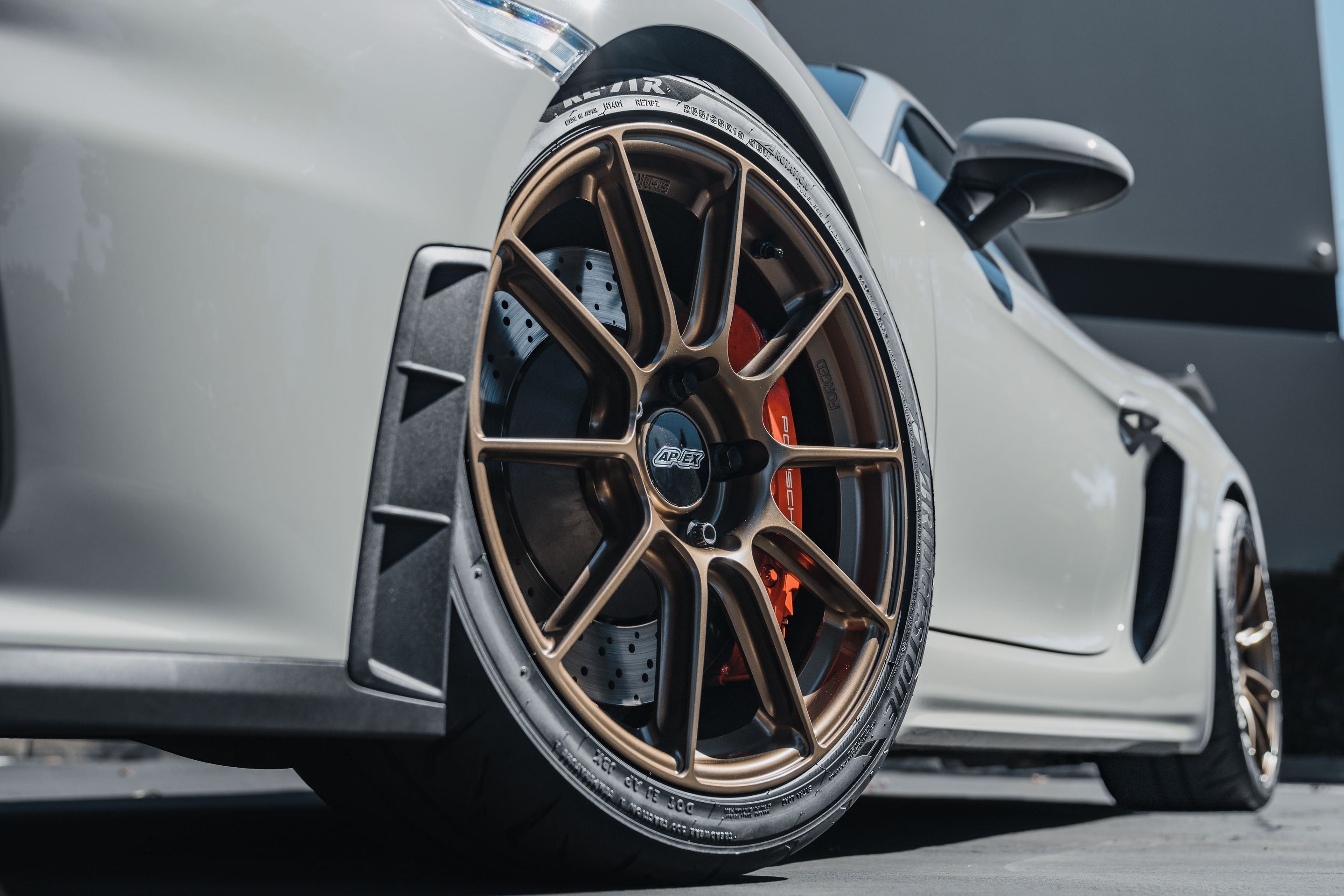 Grey Porsche 718 Cayman GT4 with 19" SM-10RS Apex wheels in Satin Bronze