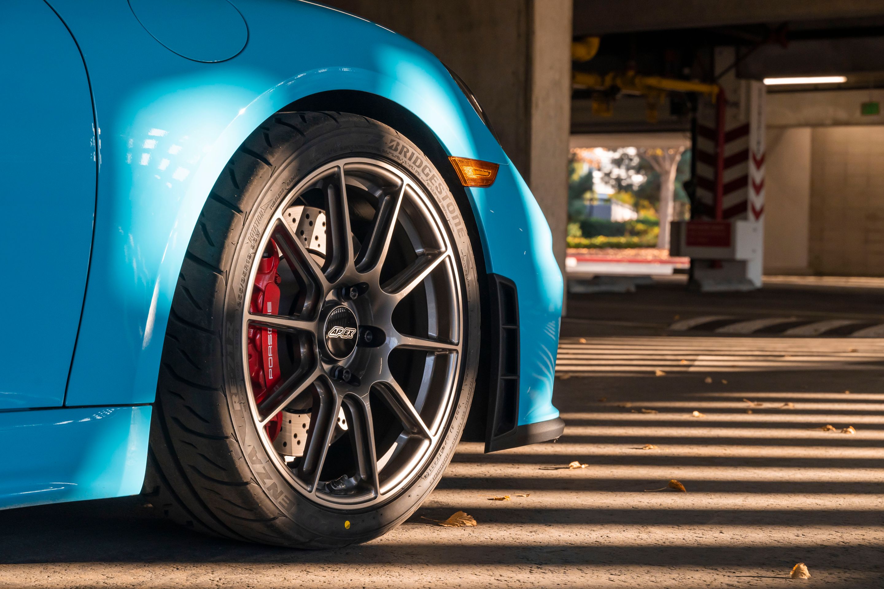 Blue Porsche 718 Cayman GT4 with 19" SM-10 Apex wheels in Anthracite