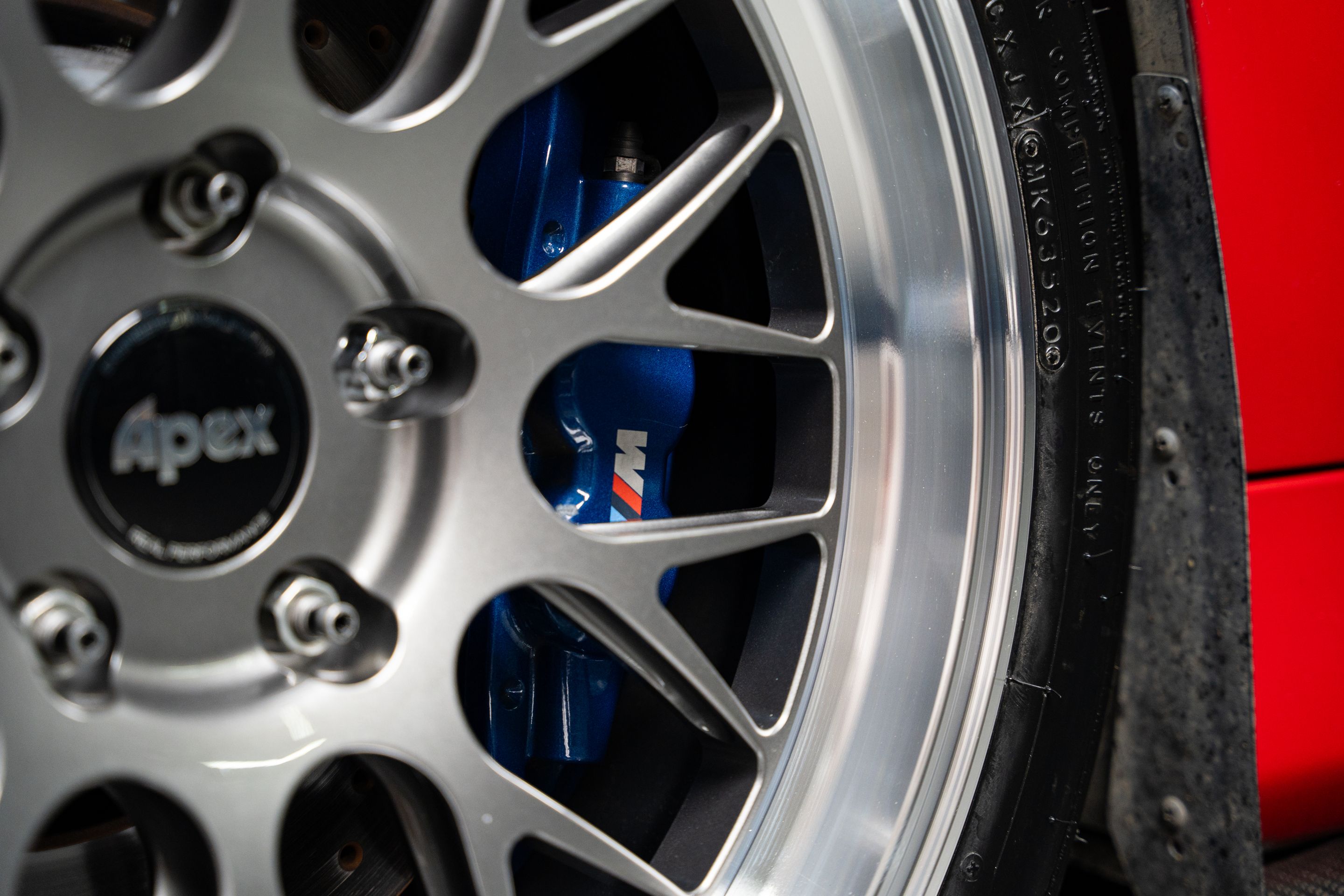 Red BMW E90 Sedan 3 Series with 18" ML-10RT Apex wheels in Machined Lip Anthracite