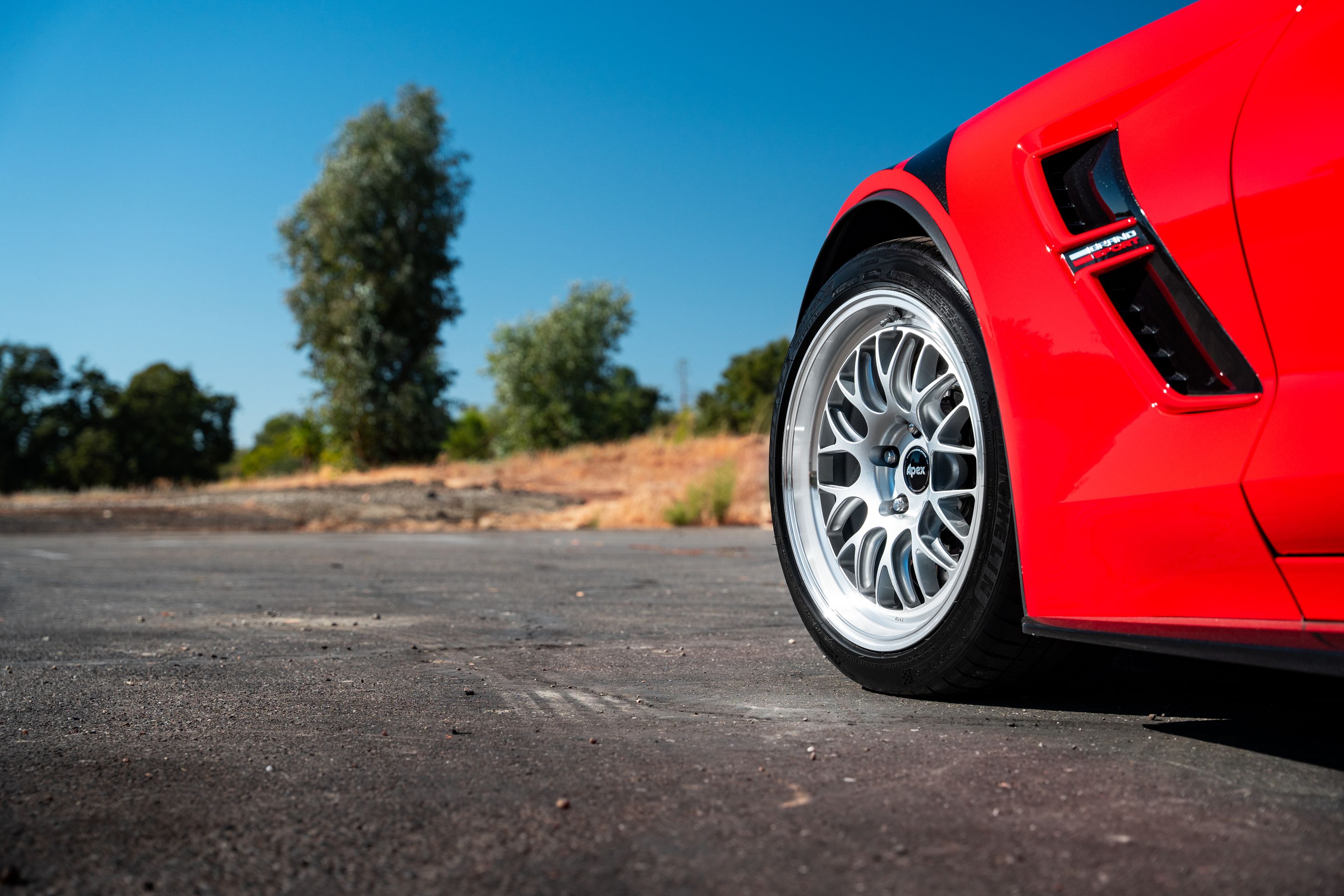 Red Chevrolet C7 Corvette Grand Sport with 18"/19" ML-10RT Apex wheels in Machined Lip Race Silver