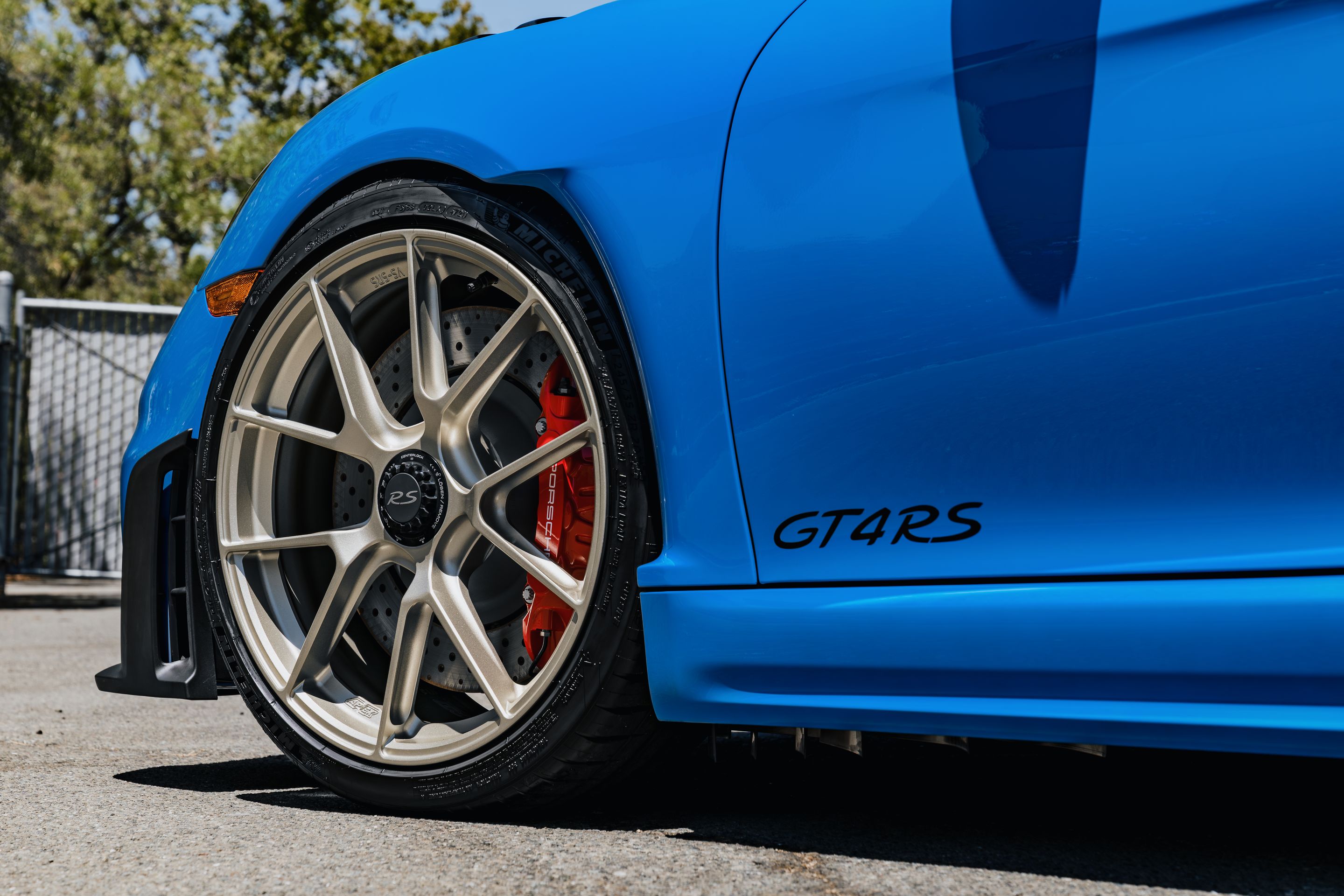 Blue Porsche 718 Cayman GT4 RS with 20" VS-5RS Apex wheels in Motorsport Gold