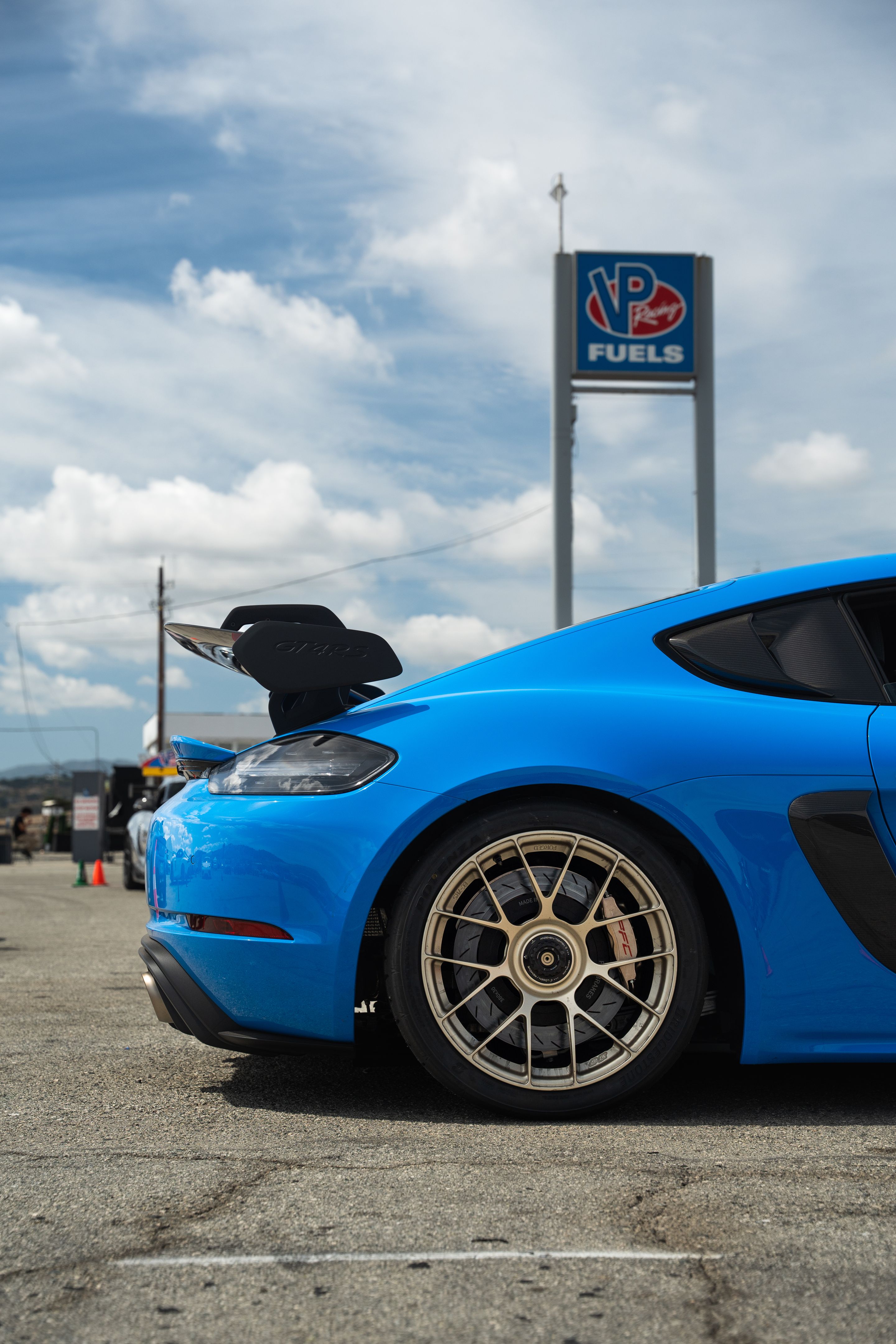 Blue Porsche 718 Cayman GT4 RS with 19" EC-7RS Apex wheels in Motorsport Gold