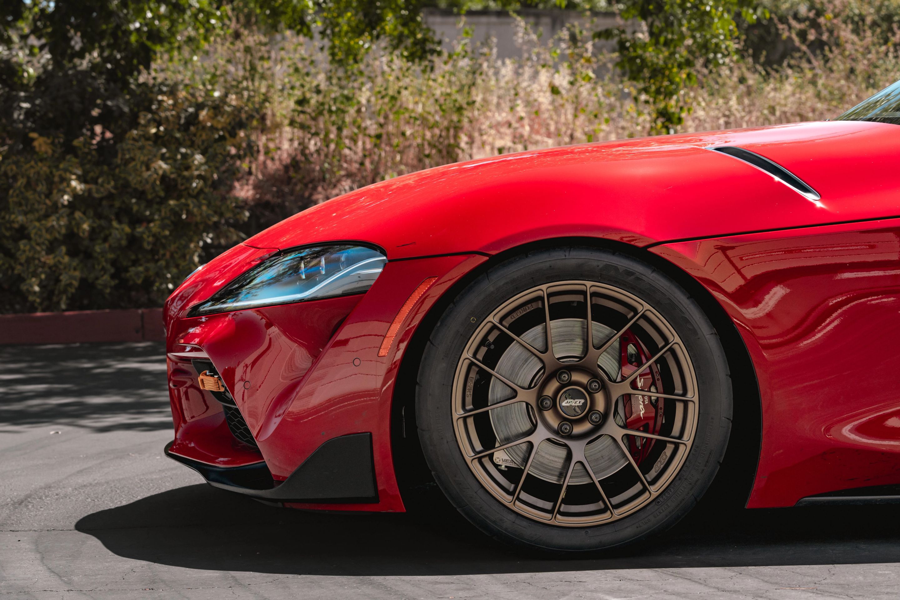 Red Toyota GR Supra with 18" EC-7RS Apex wheels in Satin Bronze