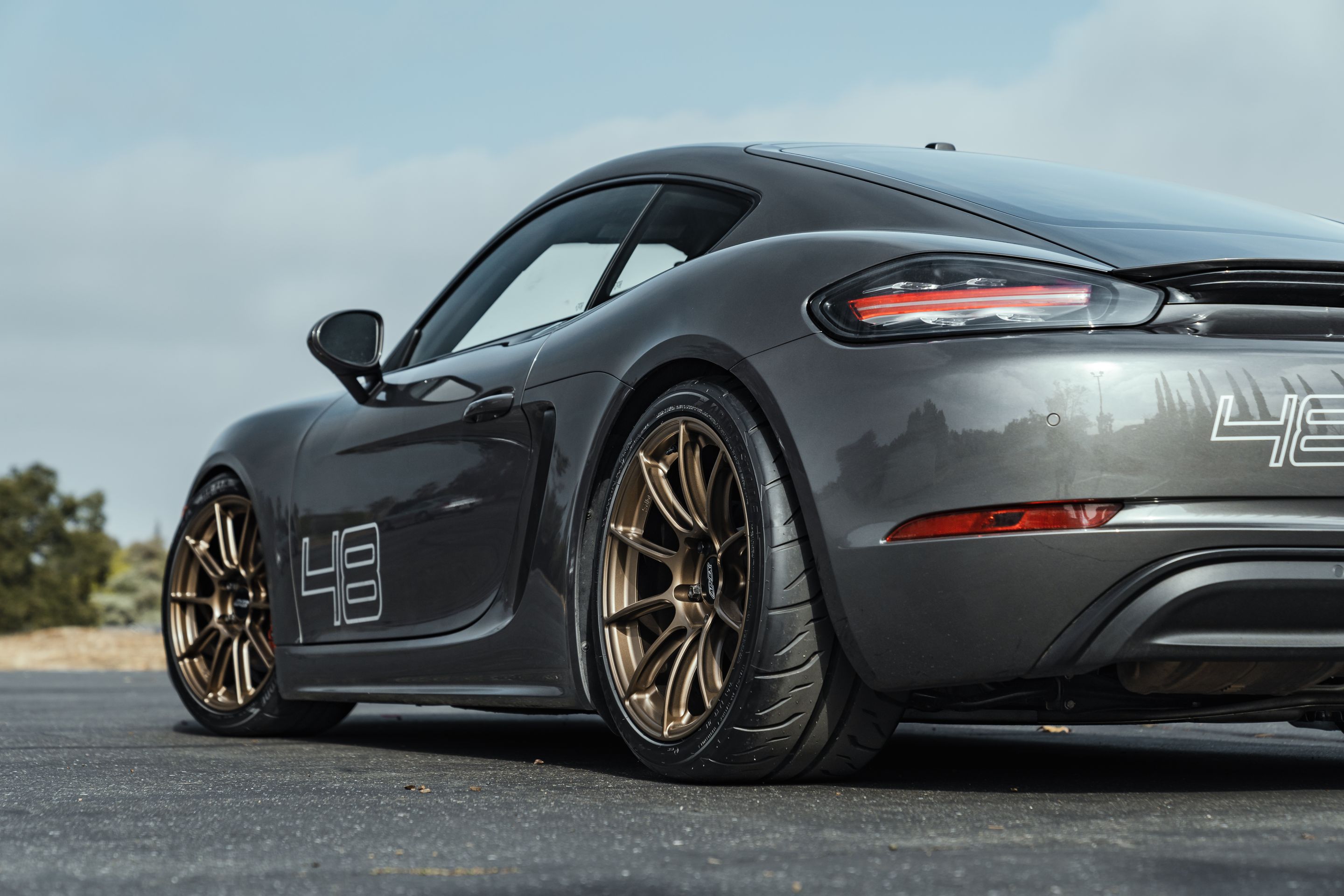 Grey Porsche 718 Cayman S with 19" SM-10RS Apex wheels in Satin Bronze