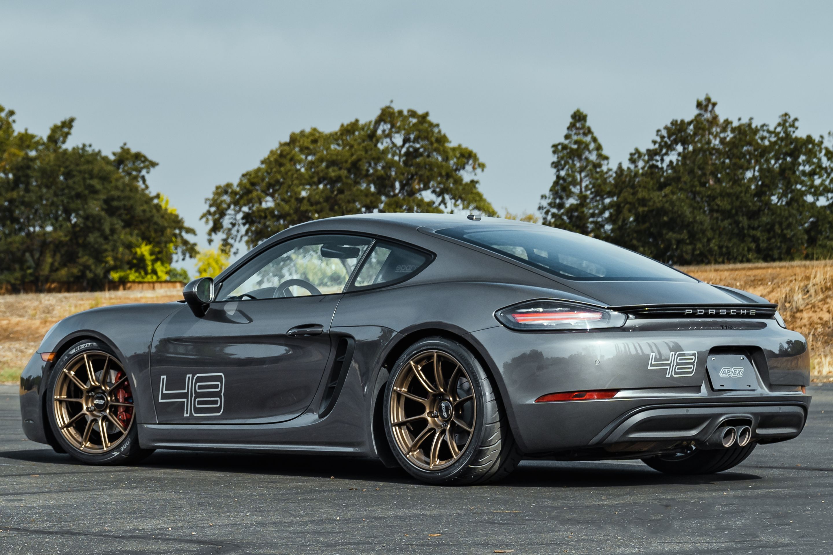 Grey Porsche 718 Cayman S with 19" SM-10RS Apex wheels in Satin Bronze