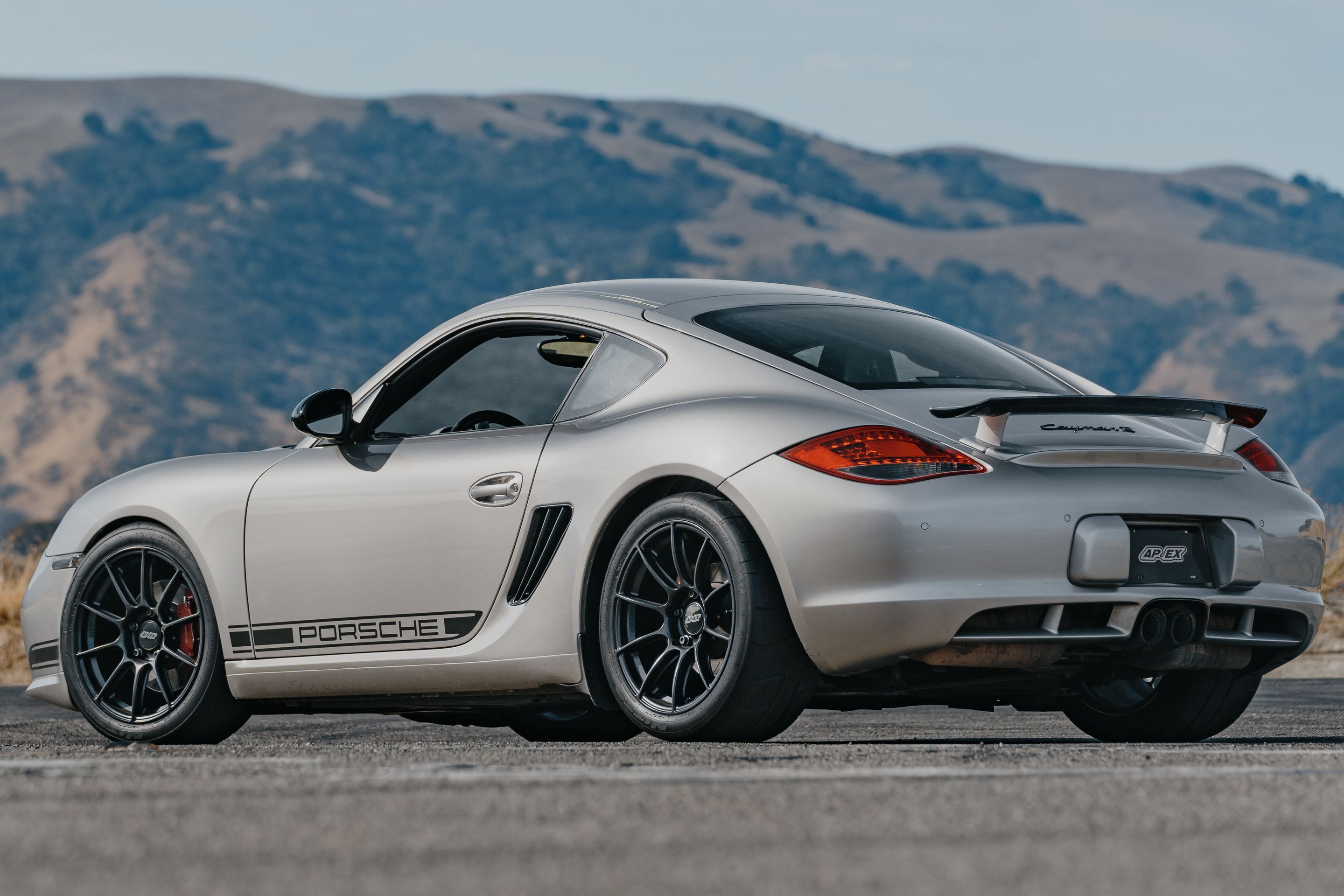 Silver Porsche 987 Cayman R with 18" SM-10RS Apex wheels in Satin Black