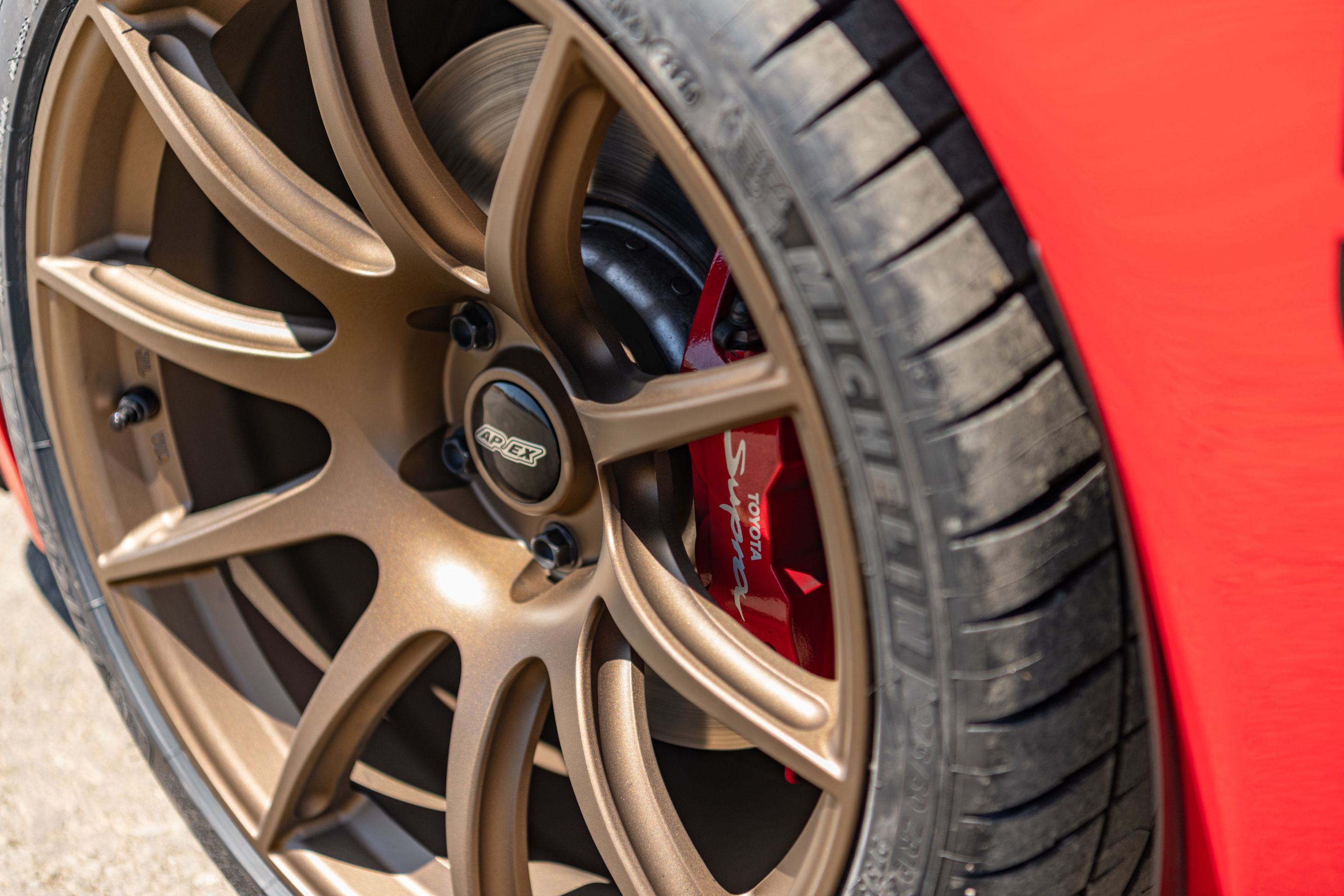 Red Toyota GR Supra with 19" SM-10 Apex wheels in Satin Bronze