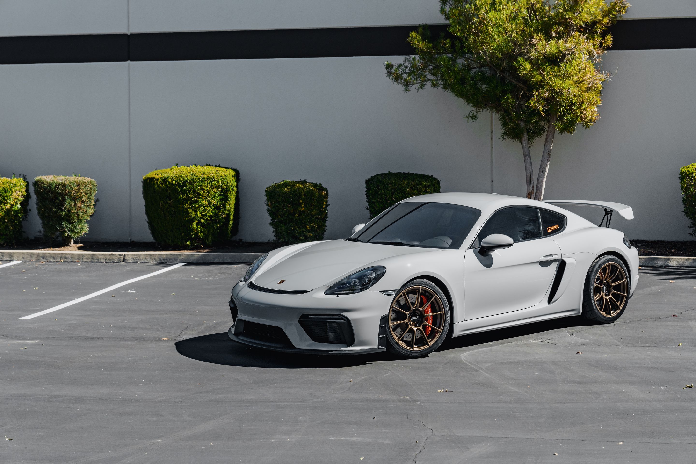 Grey Porsche 718 Cayman GT4 with 19" SM-10RS Apex wheels in Satin Bronze