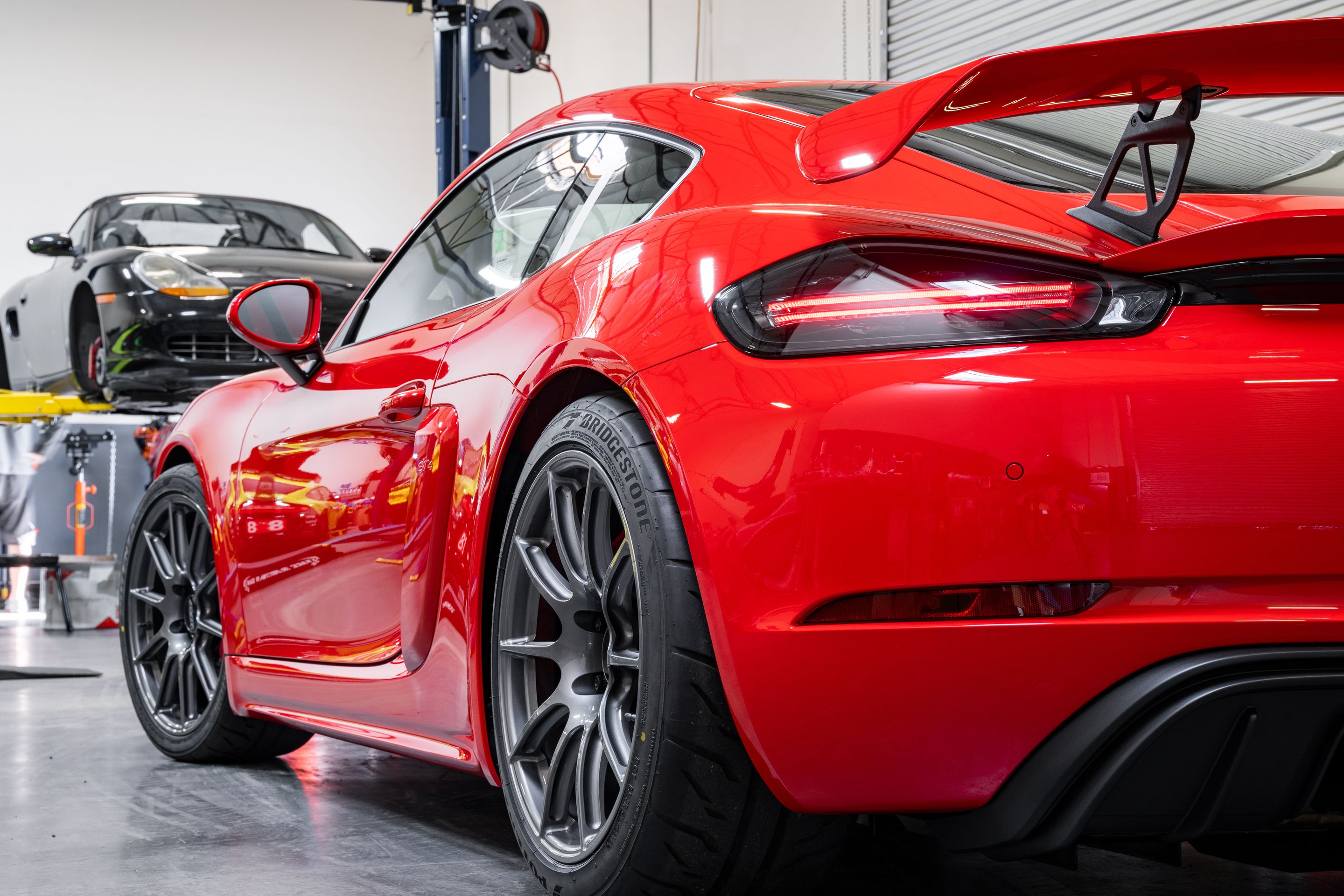 Red Porsche 718 Cayman GT4 with 19" SM-10 Apex wheels in Anthracite