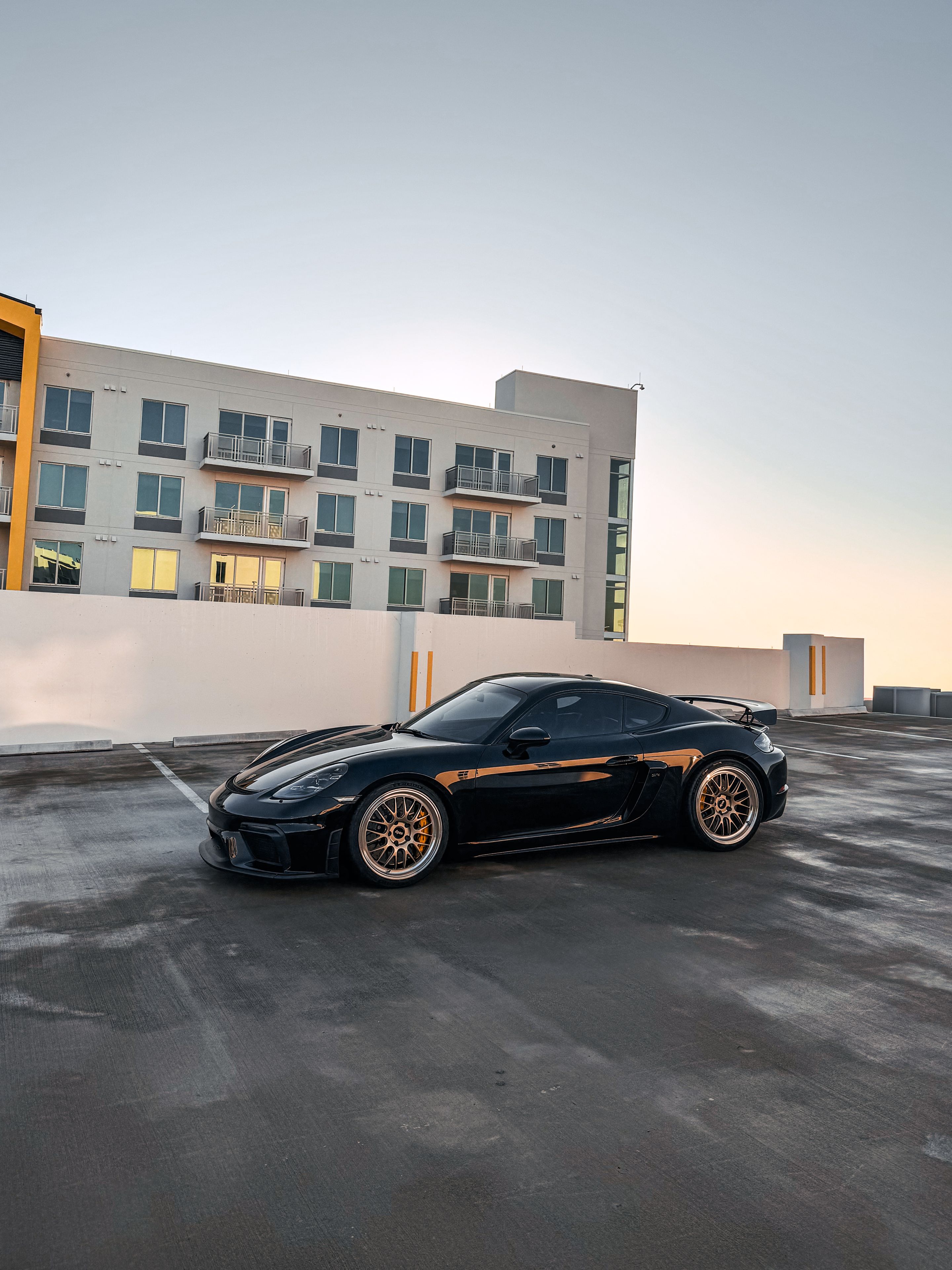 Black Porsche 718 Cayman GT4 with 20" ML-10RT Apex wheels in Machined Lip Gloss Motorsport Gold