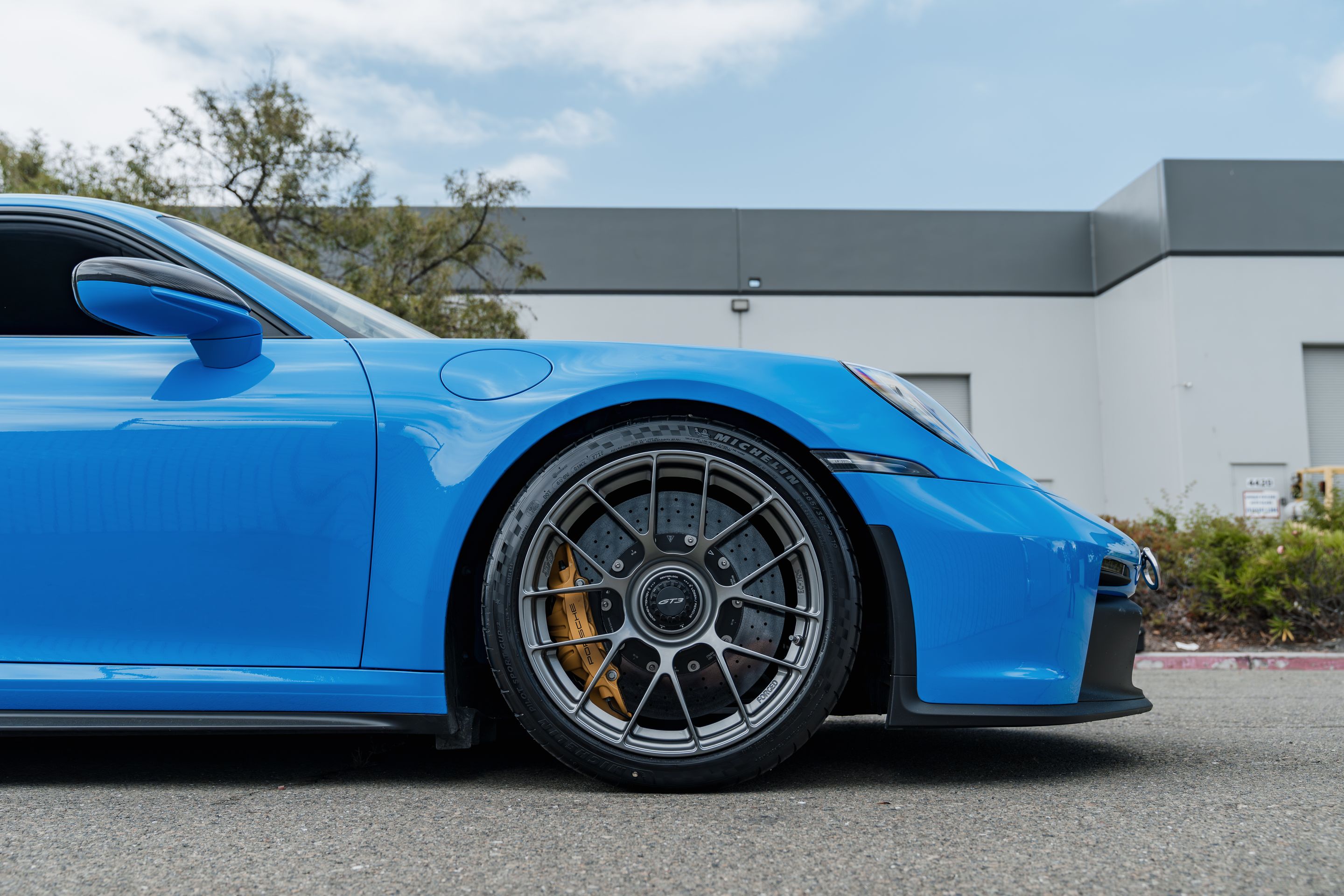 Blue Porsche 911 992.1 GT3 with 19" EC-7RS Apex wheels in Anthracite