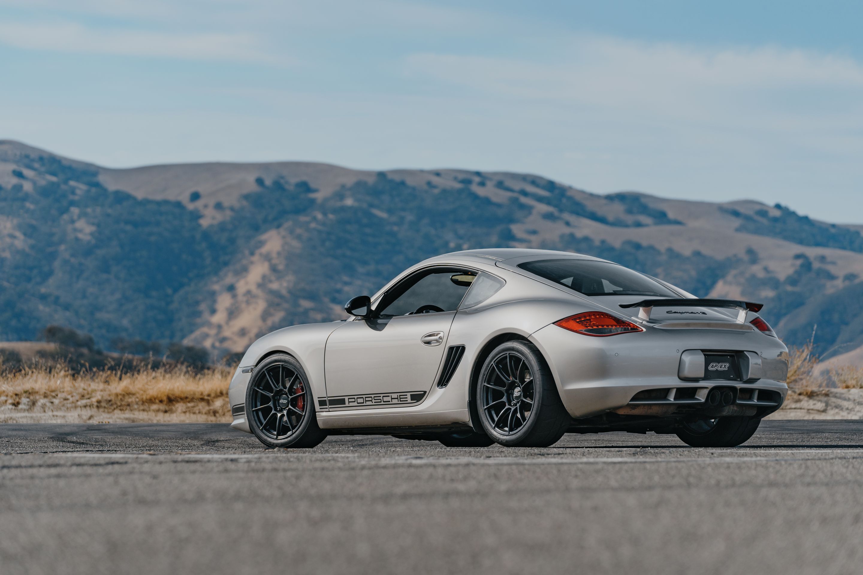 Silver Porsche 987 Cayman R with 18" SM-10RS Apex wheels in Satin Black