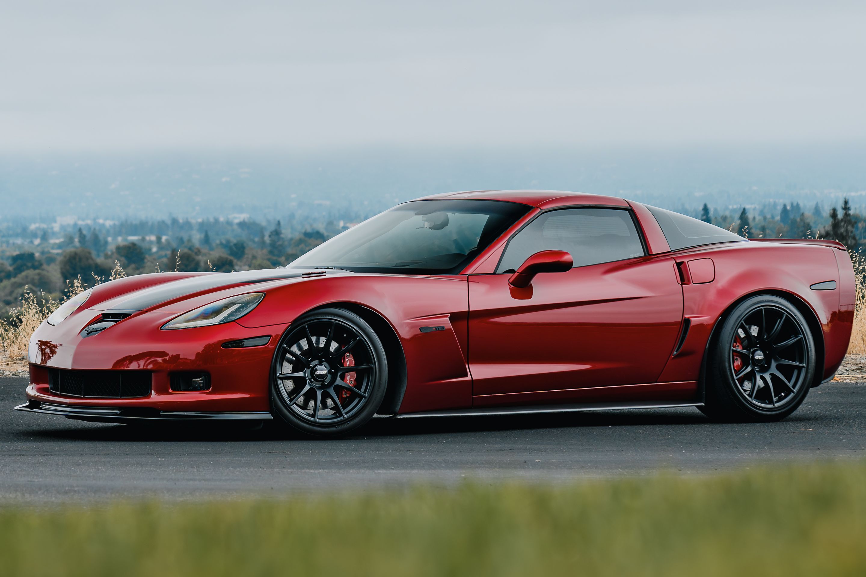Red Chevrolet C6 Corvette Z06 with 18"/19" SM-10 Apex wheels in Satin Black