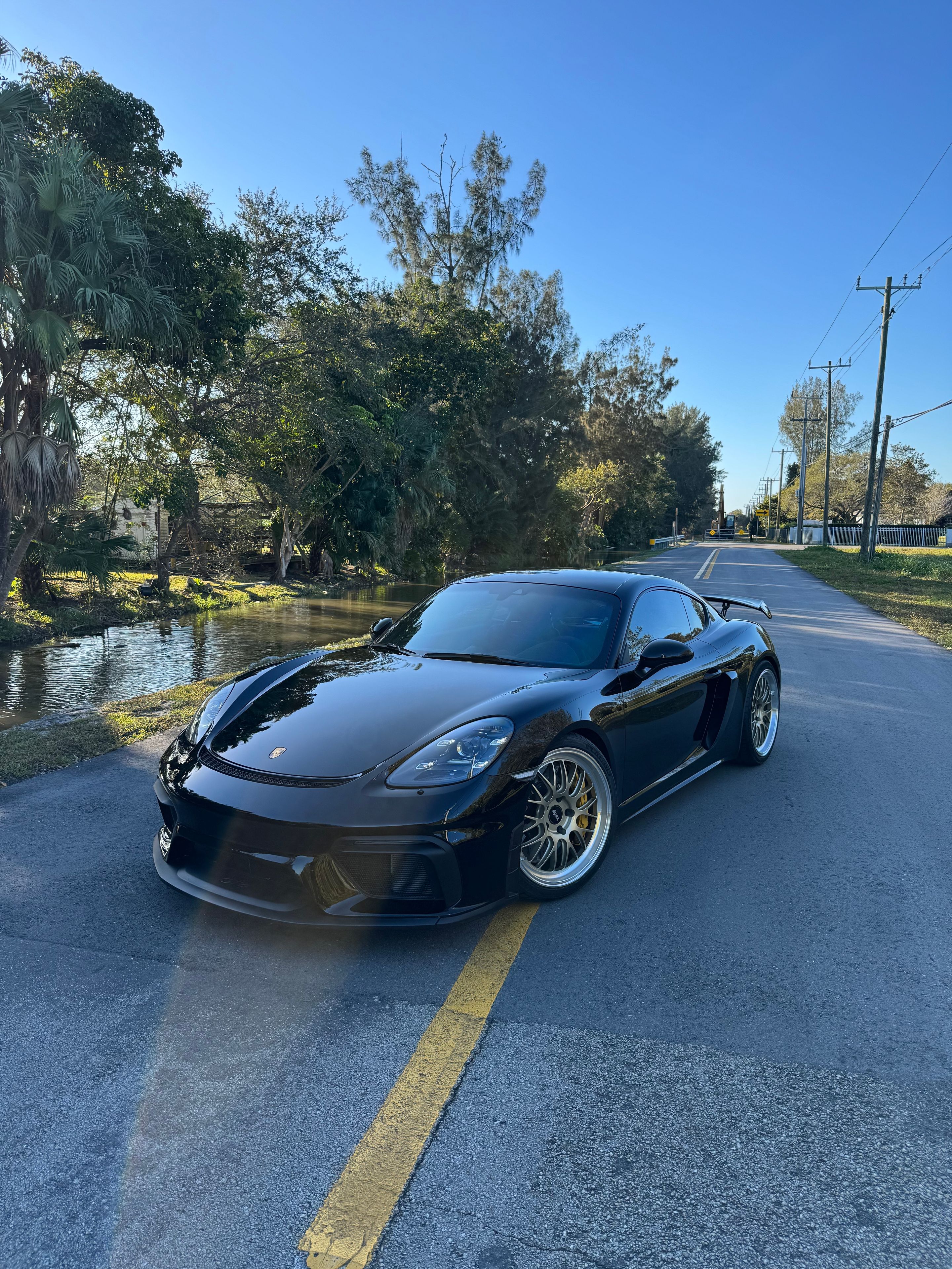 Black Porsche 718 Cayman GT4 with 20" ML-10RT Apex wheels in Machined Lip Gloss Motorsport Gold