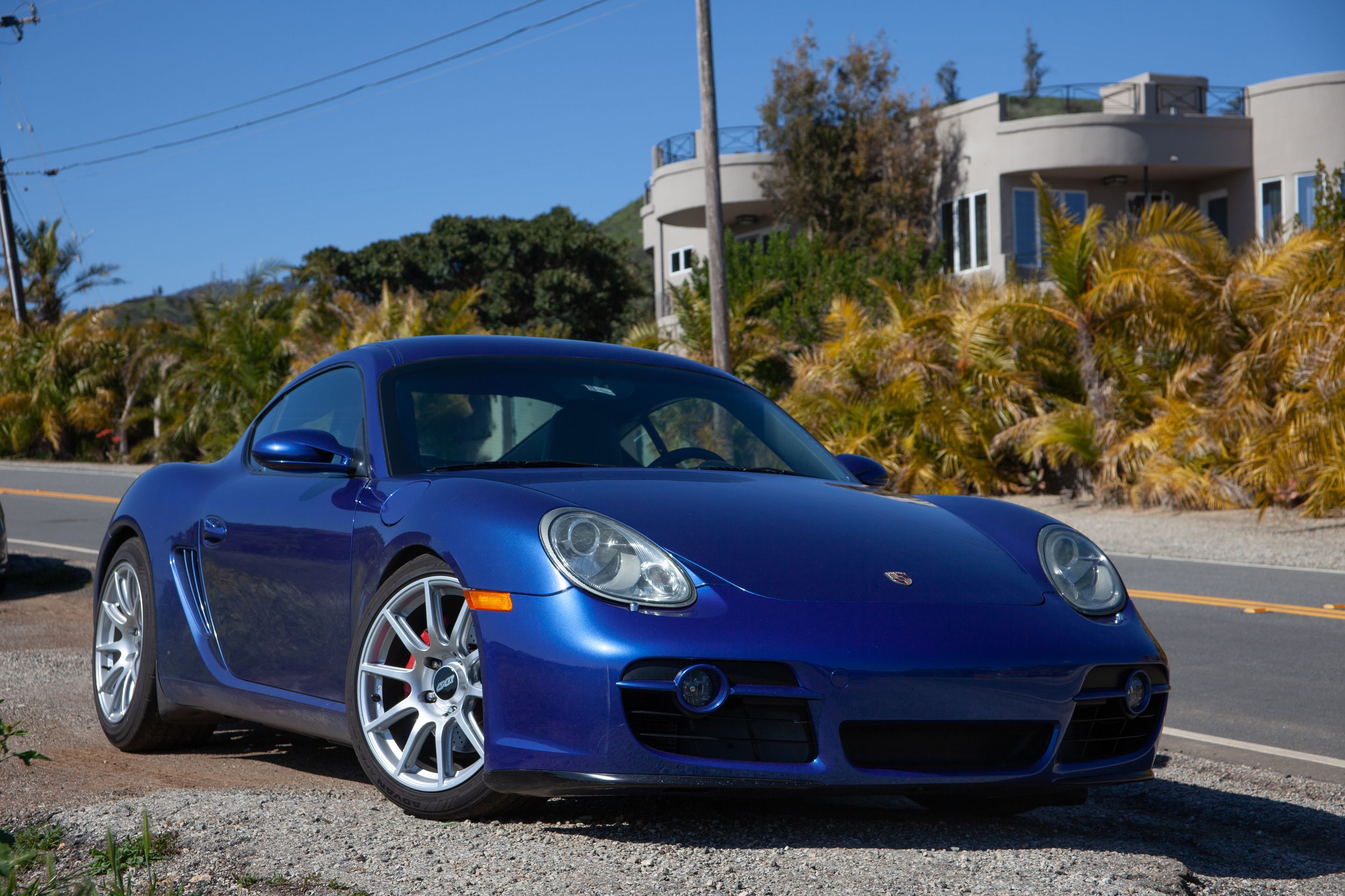 Blue Porsche 987 Cayman S with 18" SM-10 Apex wheels in Race Silver
