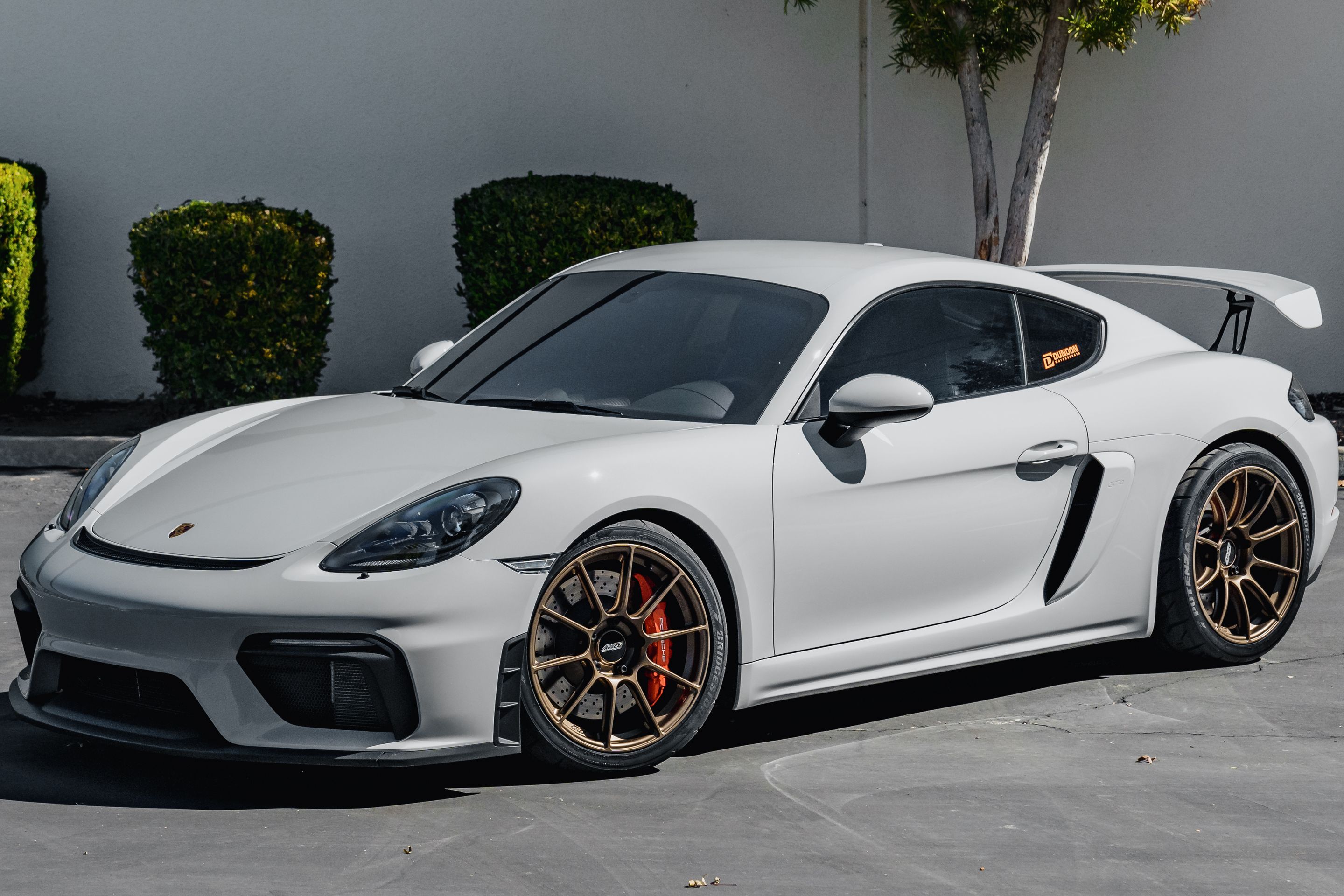 Grey Porsche 718 Cayman GT4 with 19" SM-10RS Apex wheels in Satin Bronze