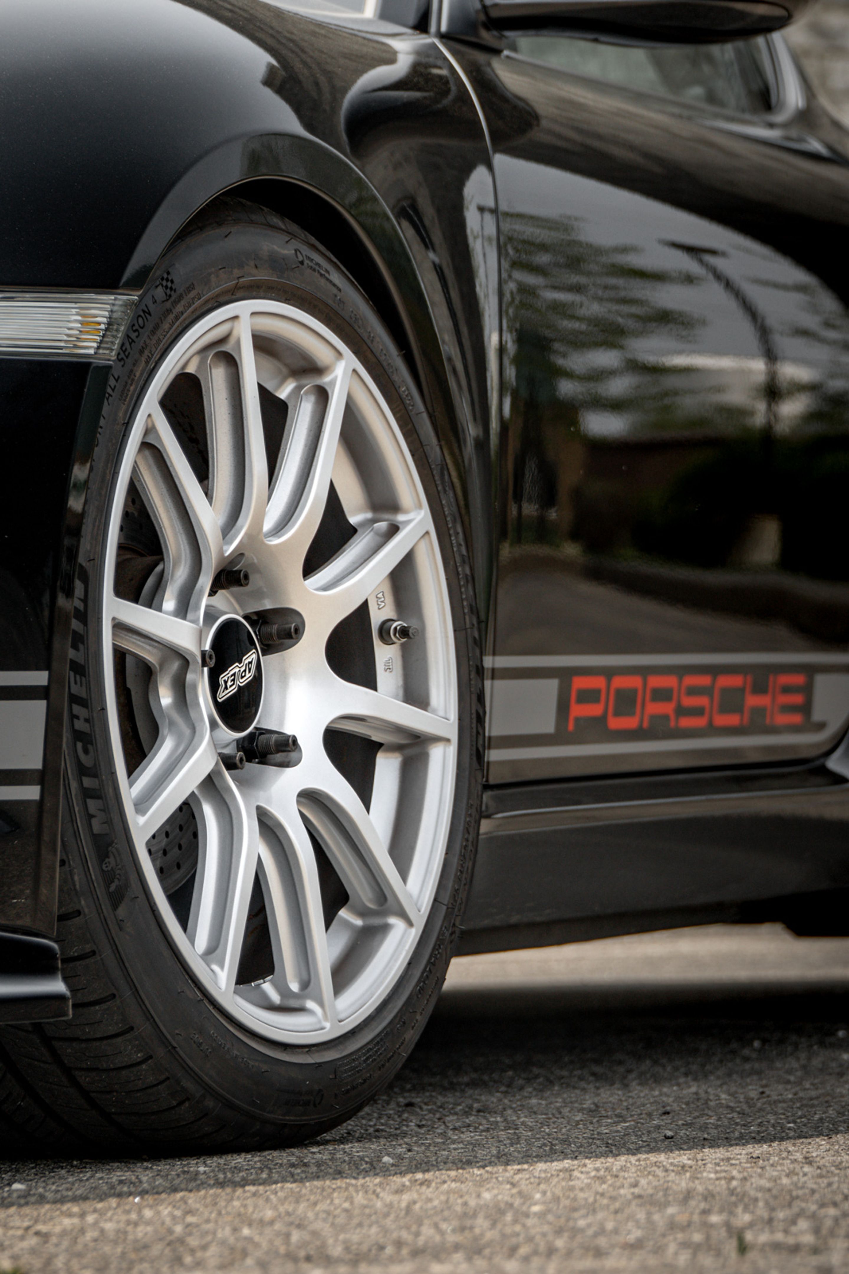 Black Porsche 987 Cayman Base with 18" SM-10 Apex wheels in Race Silver