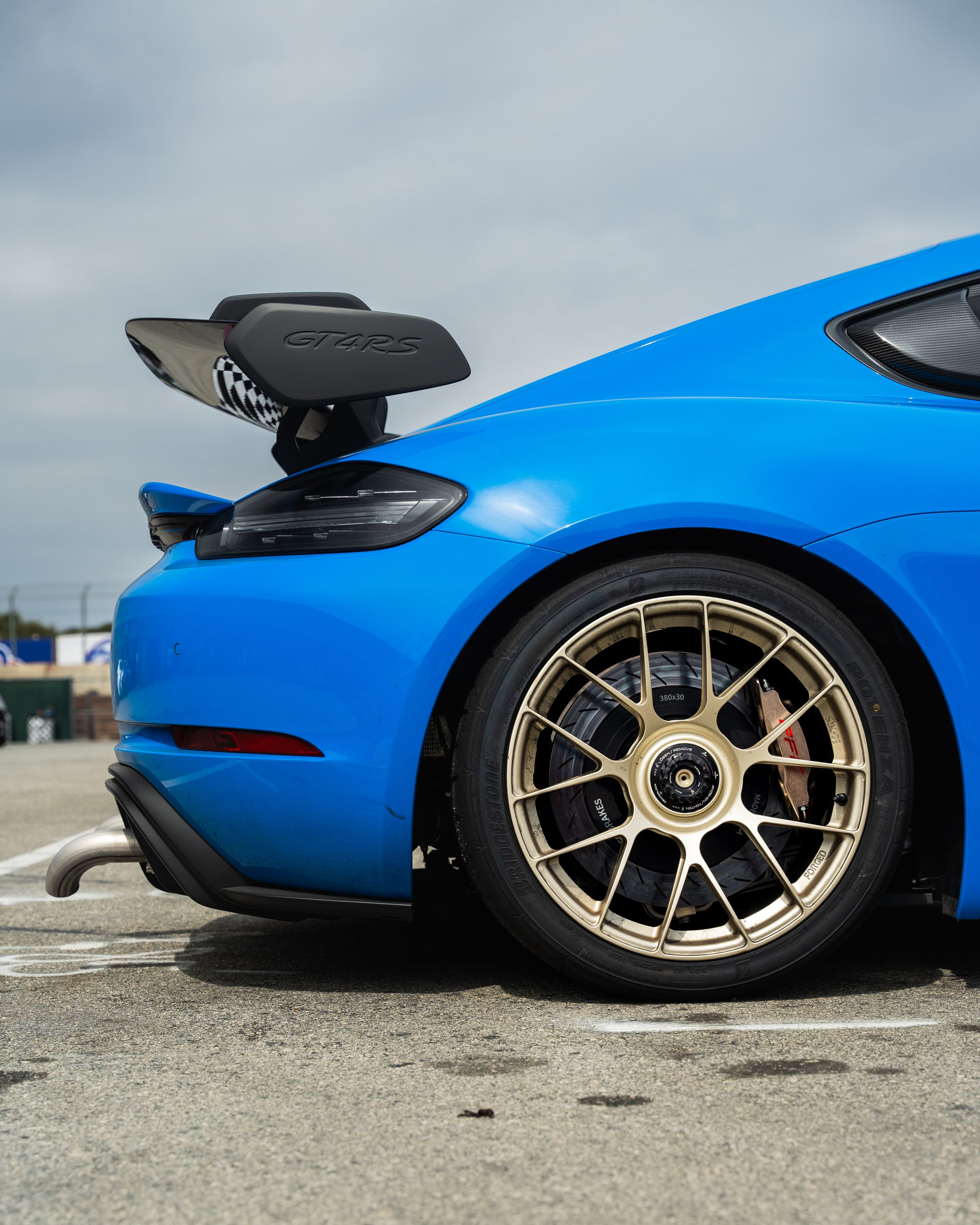 Blue Porsche 718 Cayman GT4 RS with 19" EC-7RS Apex wheels in Motorsport Gold