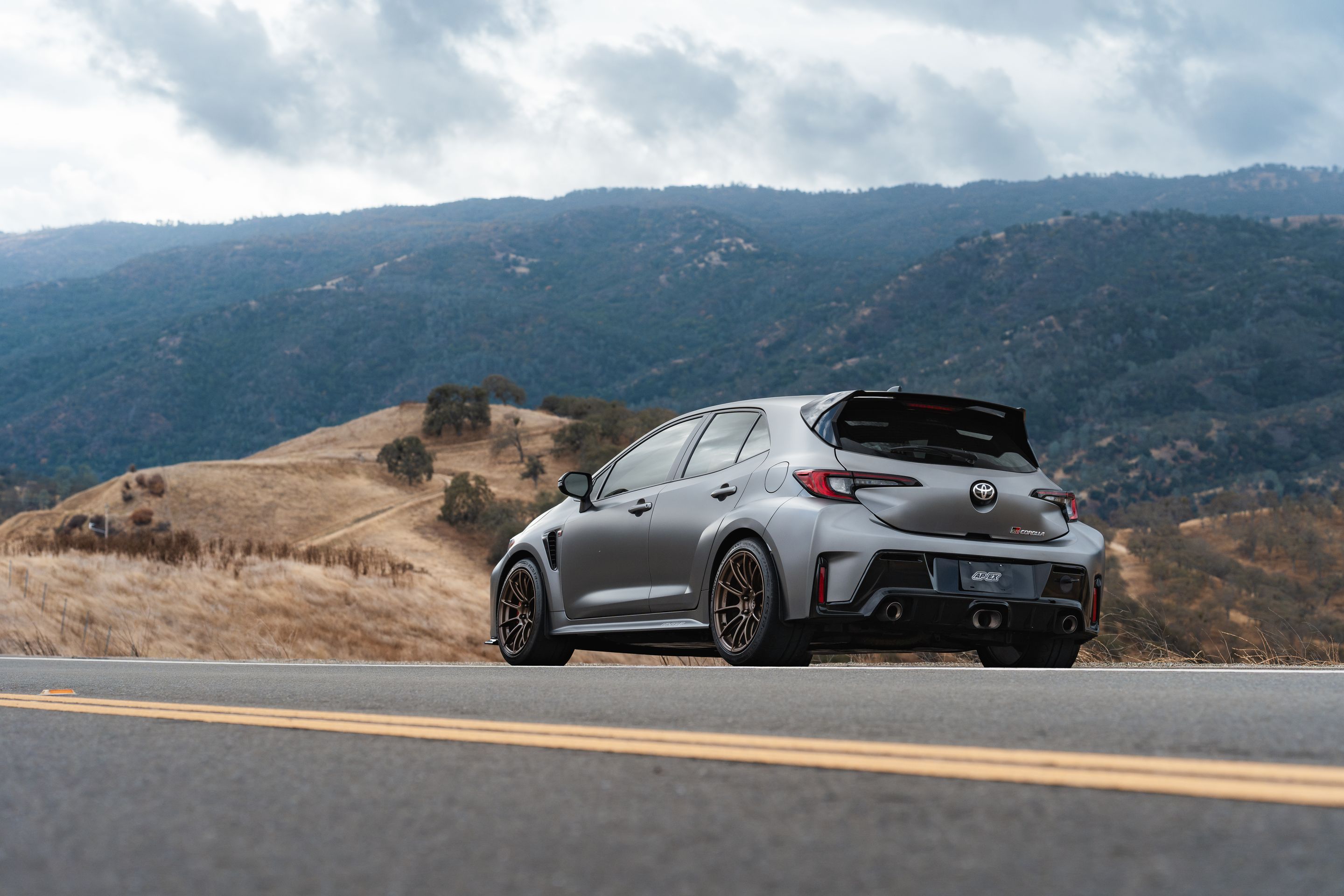 Grey Toyota GR Corolla with 18" SM-10RS Apex wheels in Satin Bronze