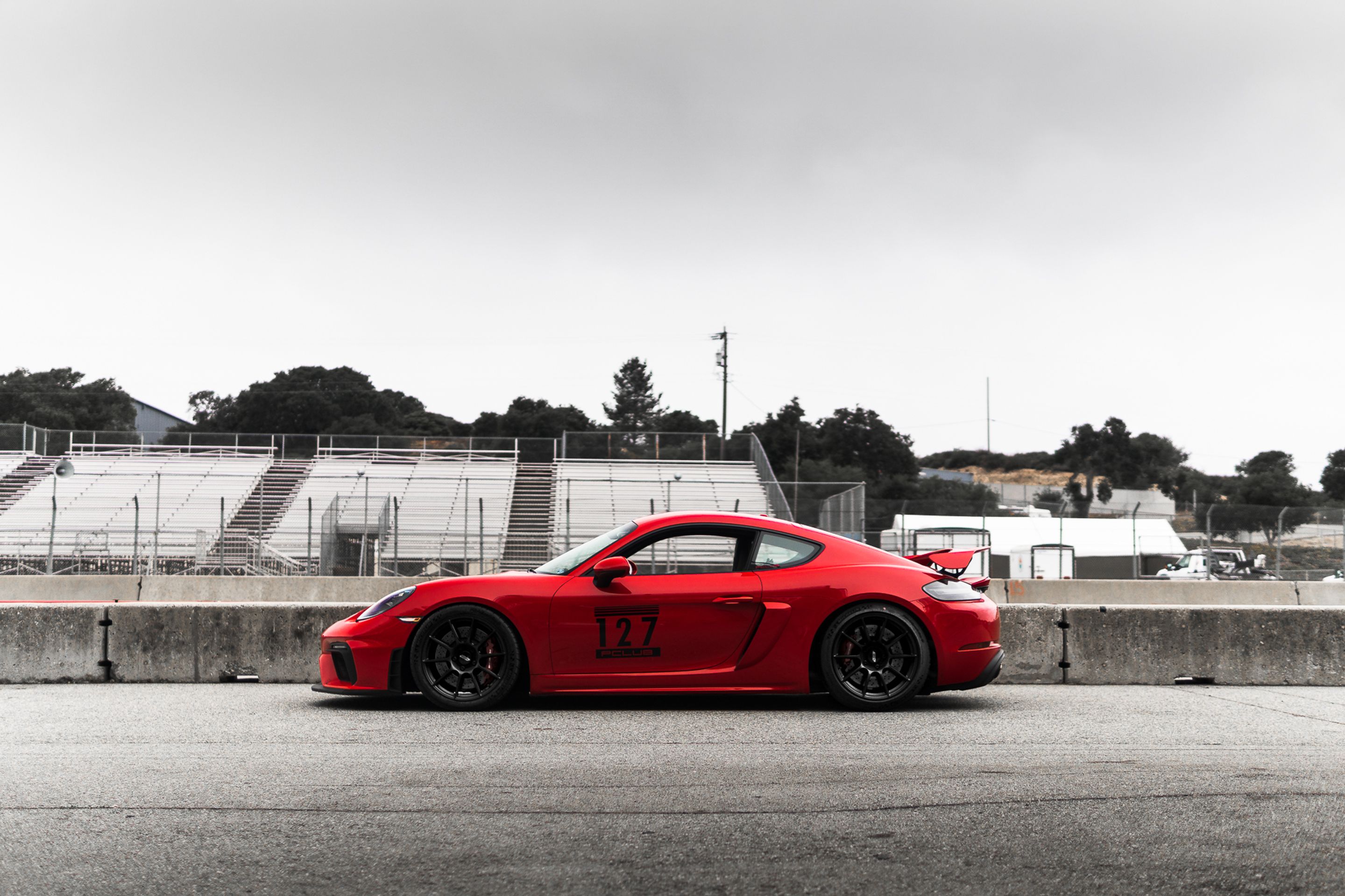 Red Porsche 718 Cayman GT4 with 19" SM-10 Apex wheels in Satin Black