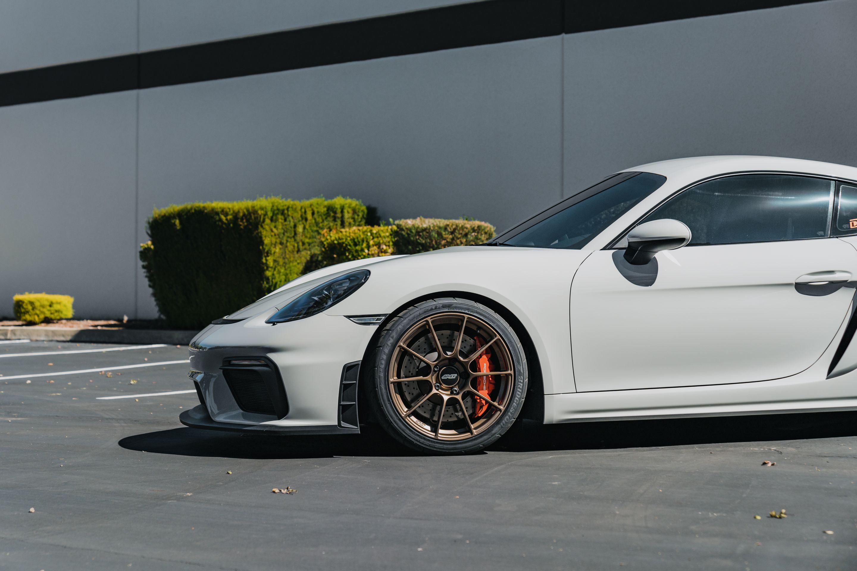 Grey Porsche 718 Cayman GT4 with 19" SM-10RS Apex wheels in Satin Bronze
