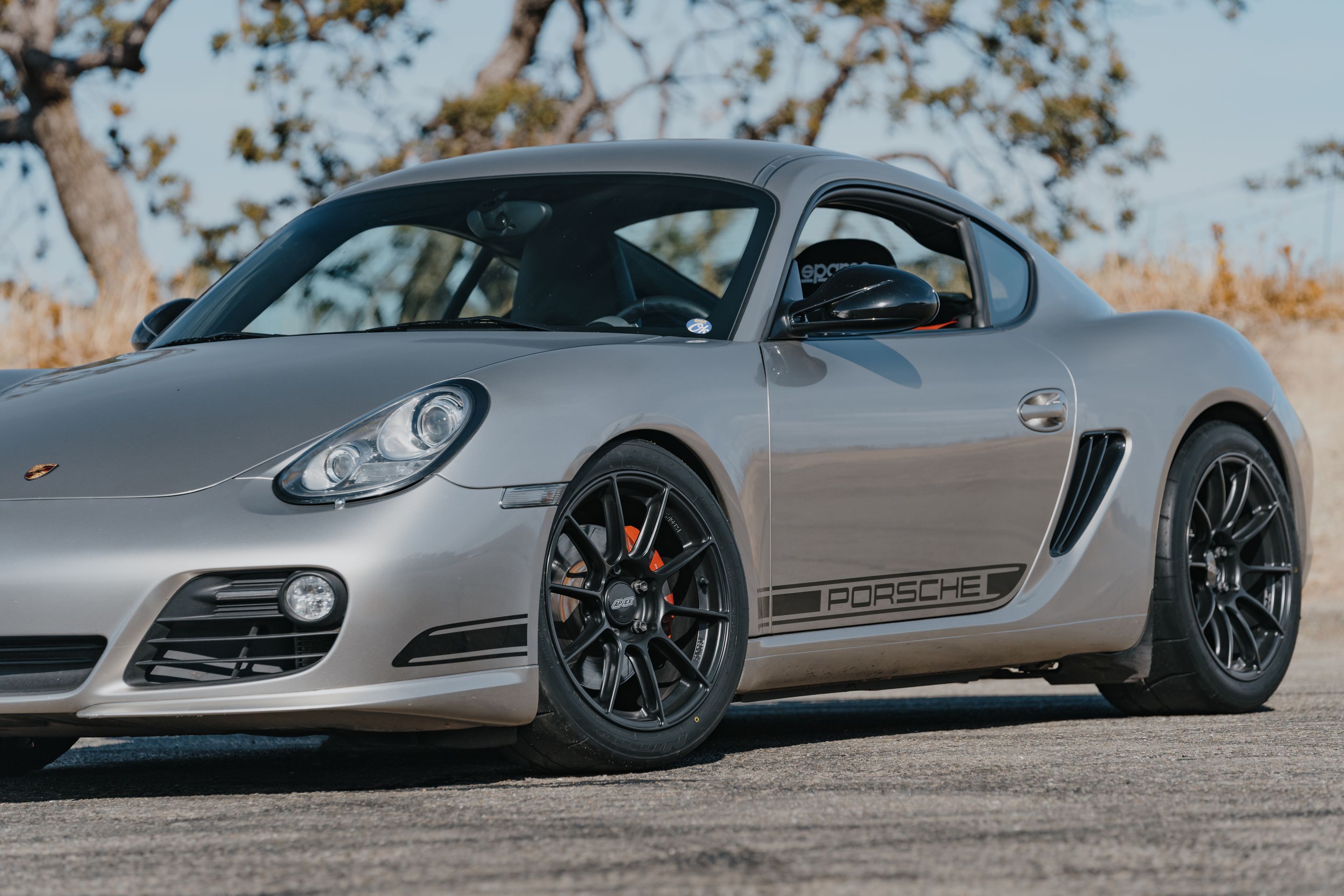 Silver Porsche 987 Cayman R with 18" SM-10RS Apex wheels in Satin Black