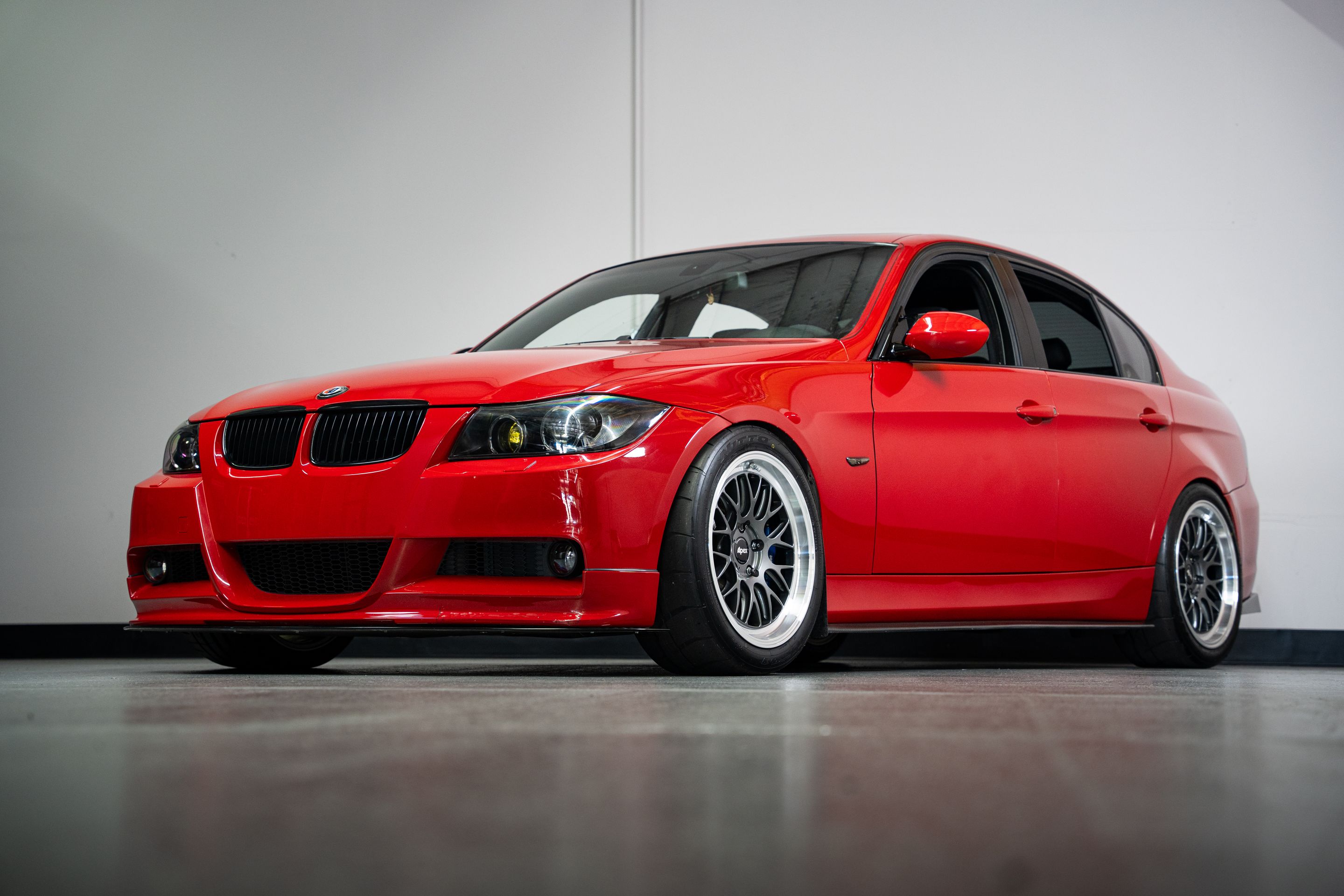 Red BMW E90 Sedan 3 Series with 18" ML-10RT Apex wheels in Machined Lip Anthracite