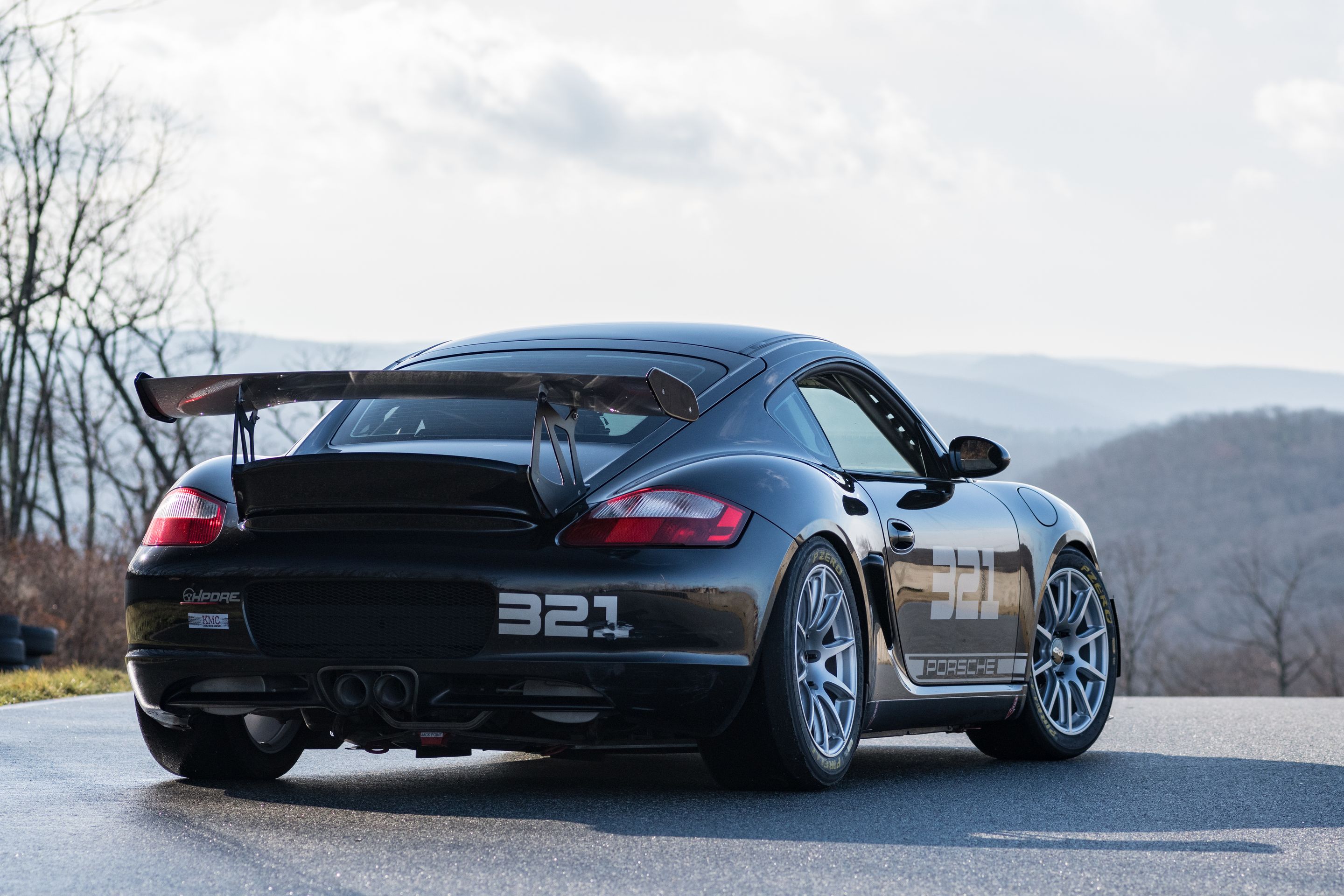 Black Porsche 987 Cayman S with 18" SM-10 Apex wheels in Race Silver