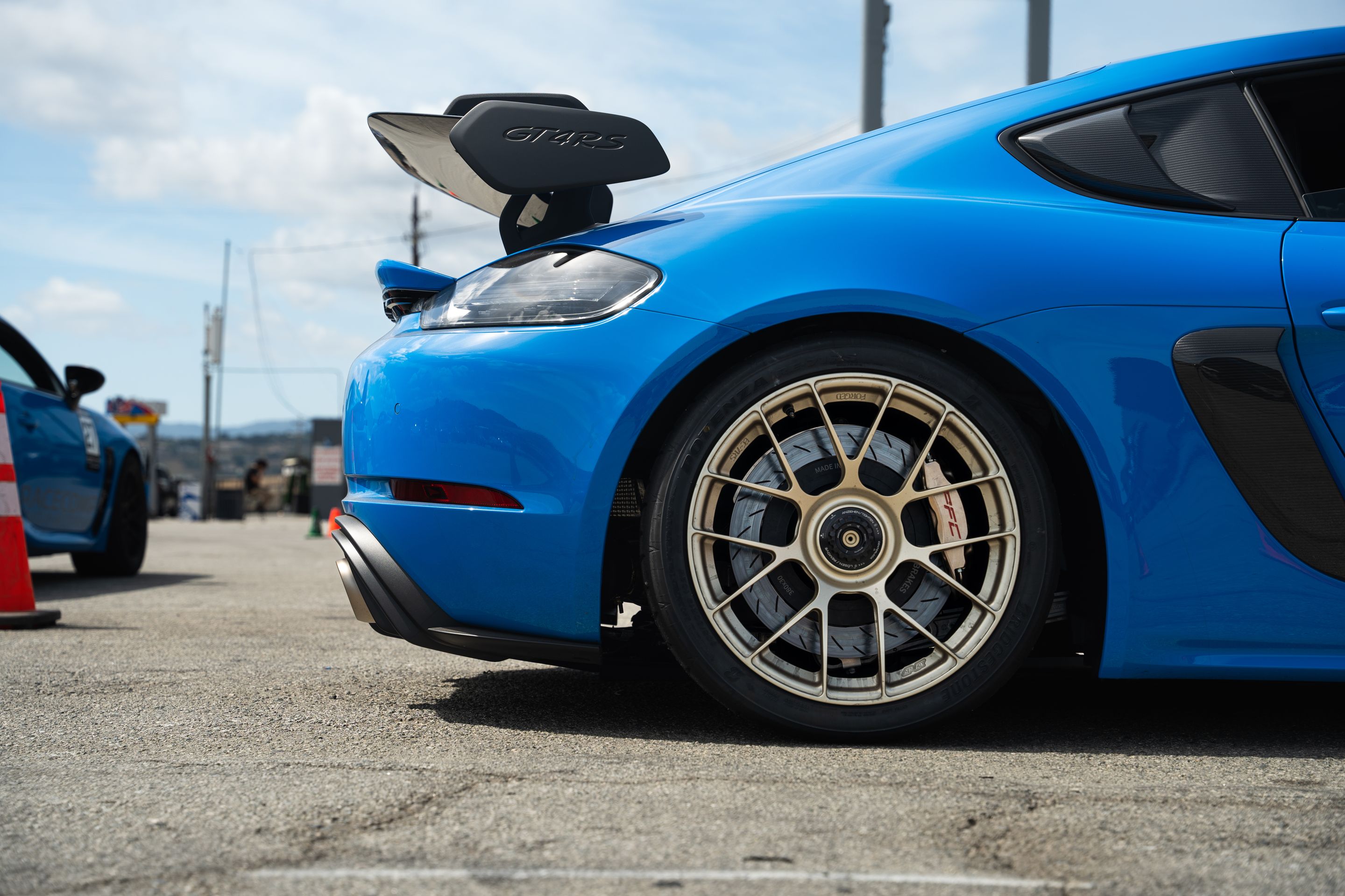 Blue Porsche 718 Cayman GT4 RS with 19" EC-7RS Apex wheels in Motorsport Gold