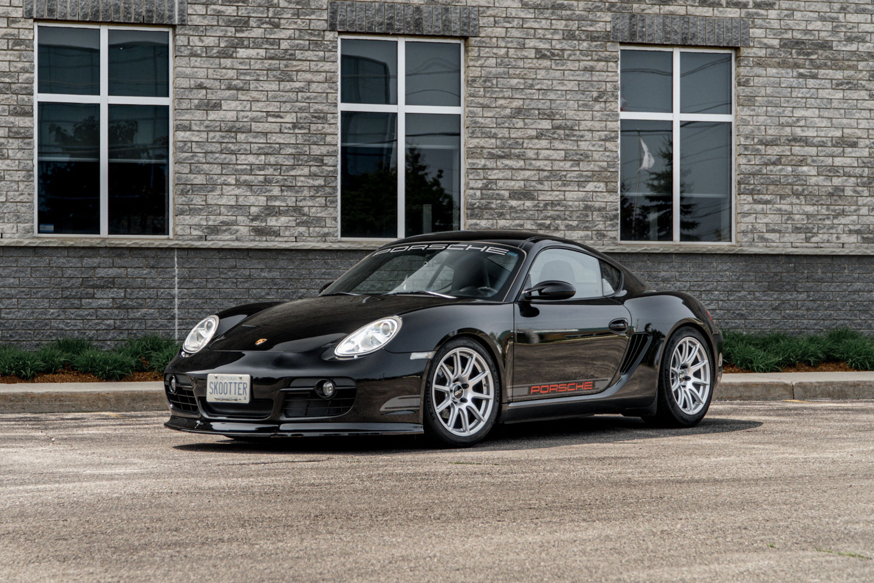 Black Porsche 987 Cayman Base with 18" SM-10 Apex wheels in Race Silver