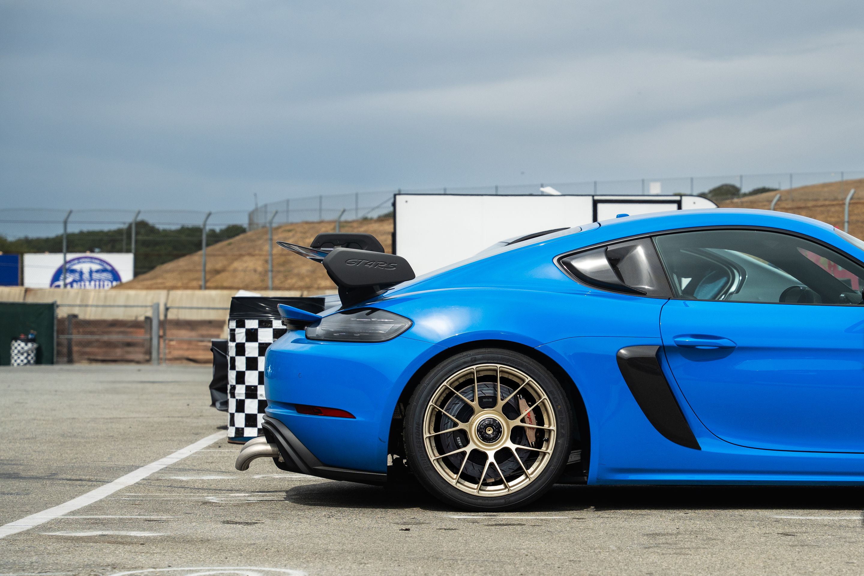 Blue Porsche 718 Cayman GT4 RS with 19" EC-7RS Apex wheels in Motorsport Gold