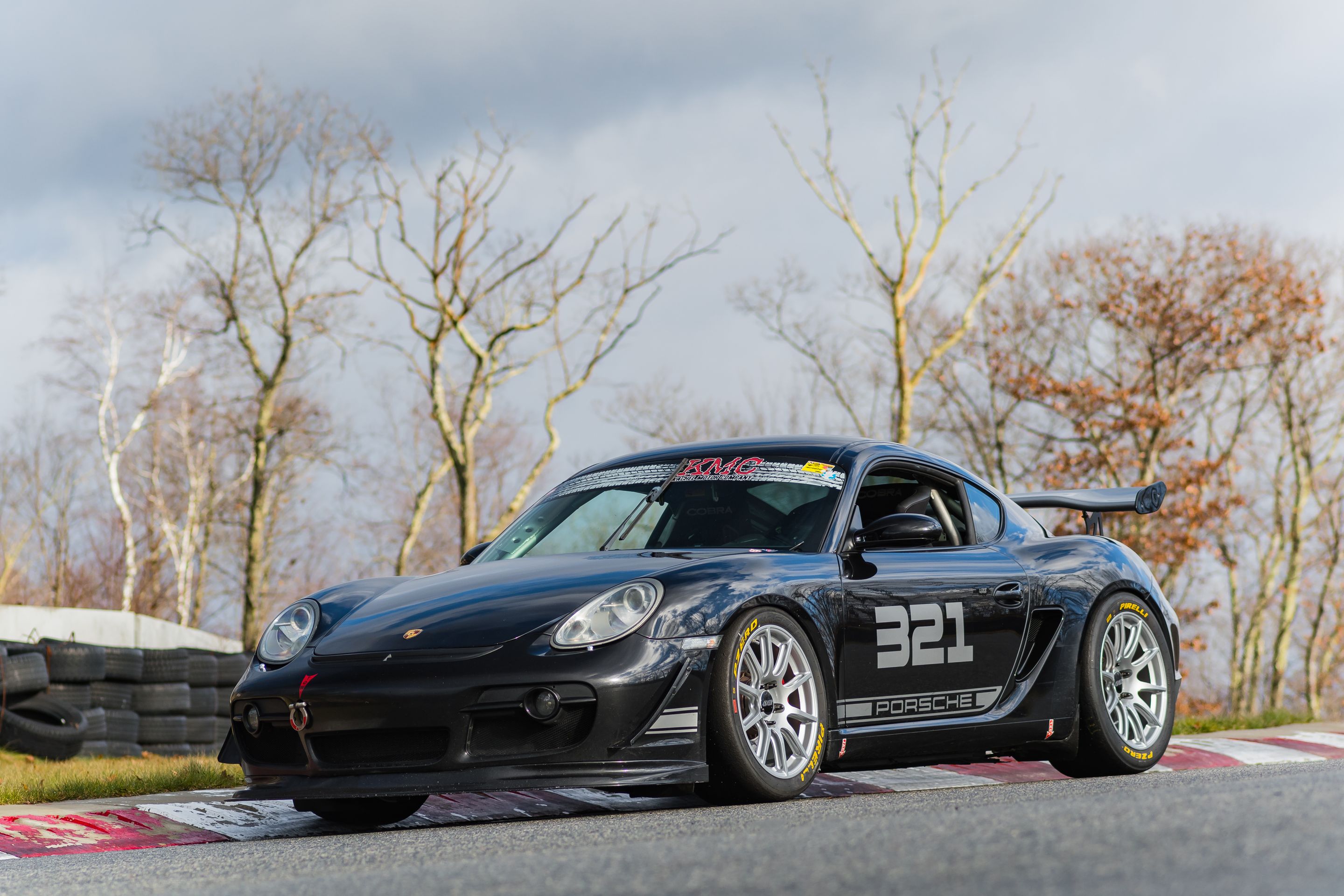 Black Porsche 987 Cayman S with 18" SM-10 Apex wheels in Race Silver