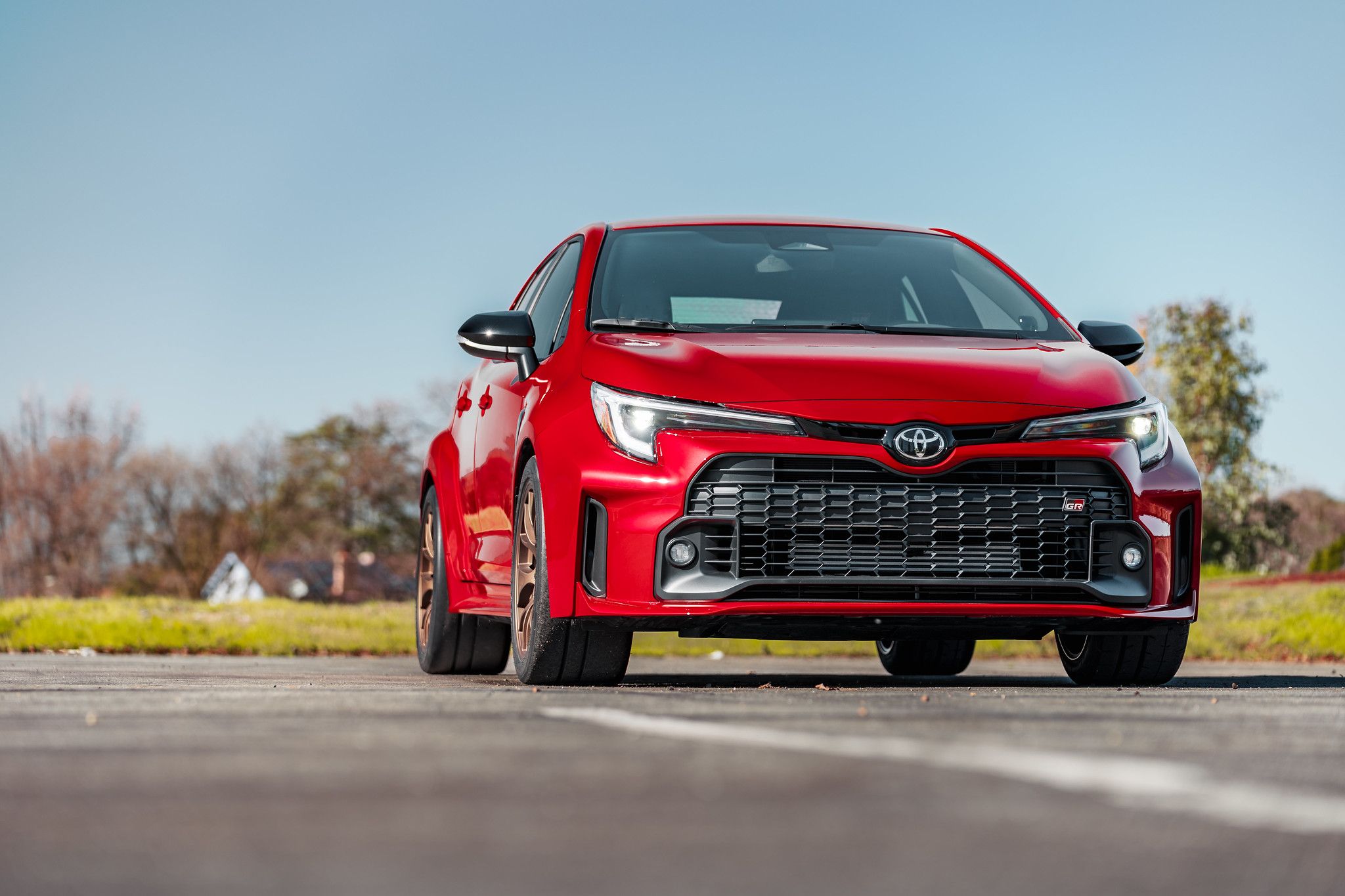 Red Toyota GR Corolla with 18" EC-7 Apex wheels in Satin Bronze