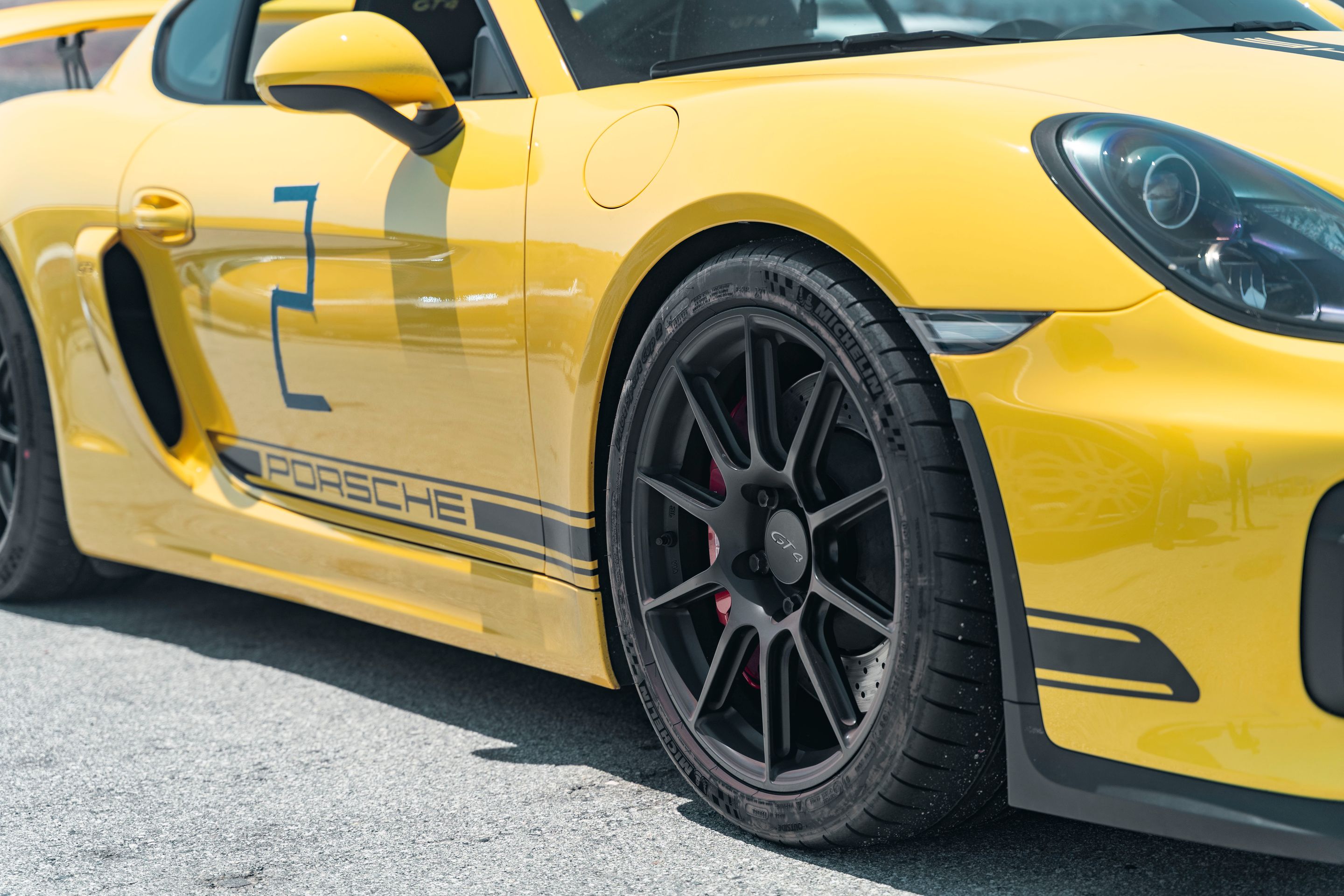 Yellow Porsche 981 Cayman GT4 with 19" SM-10 Apex wheels in Satin Black