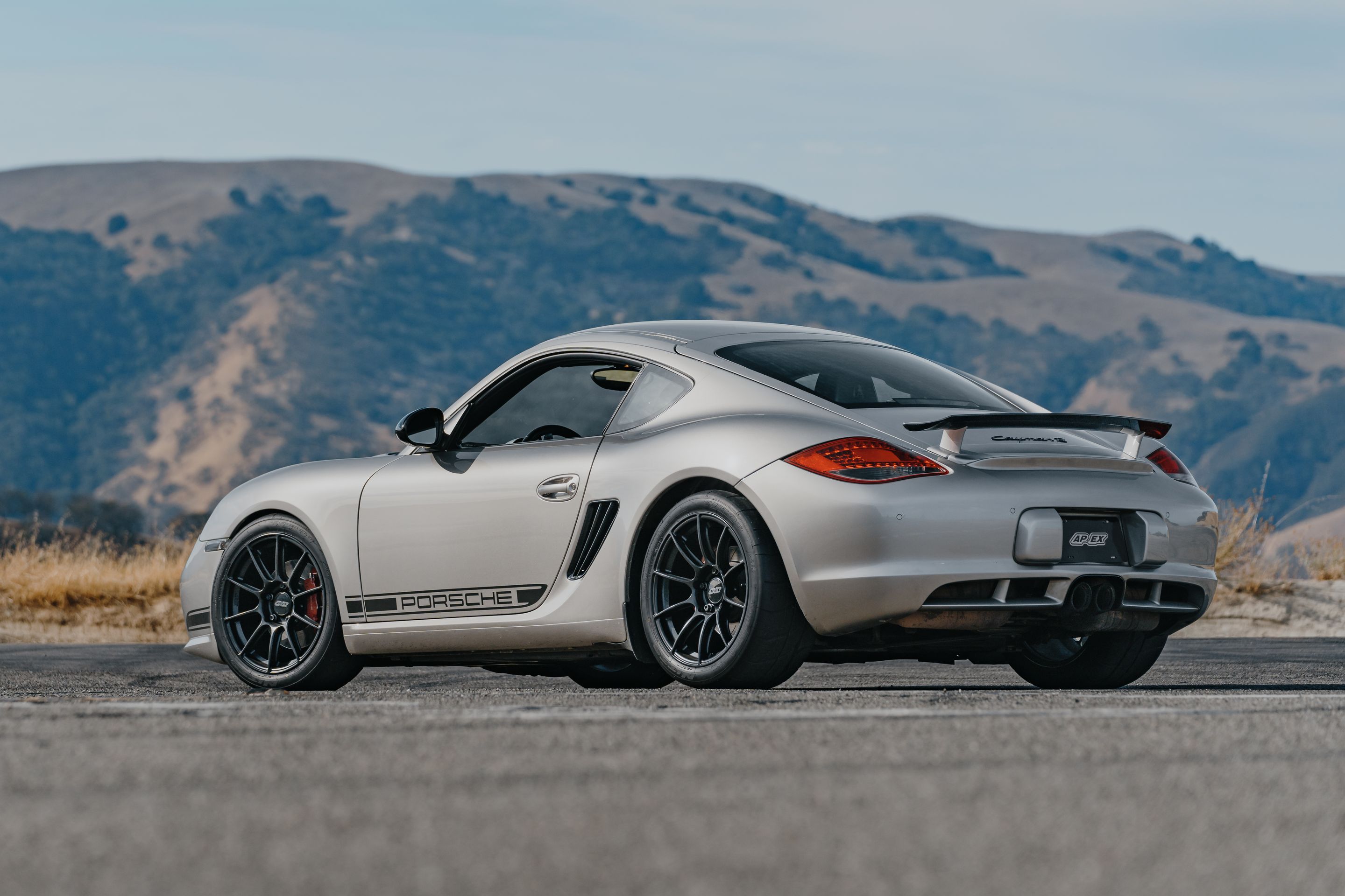 Silver Porsche 987 Cayman R with 18" SM-10RS Apex wheels in Satin Black