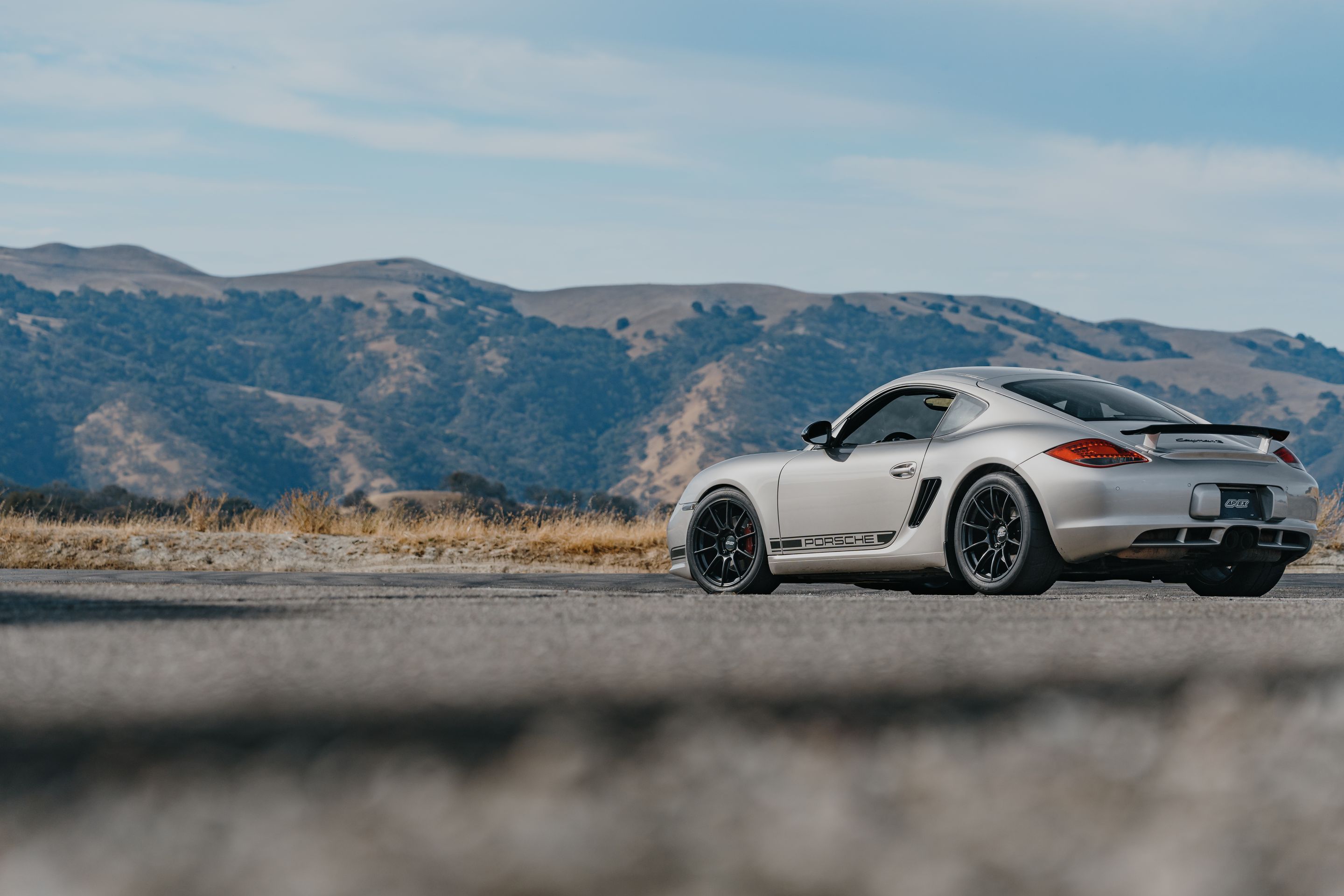 Silver Porsche 987 Cayman R with 18" SM-10RS Apex wheels in Satin Black