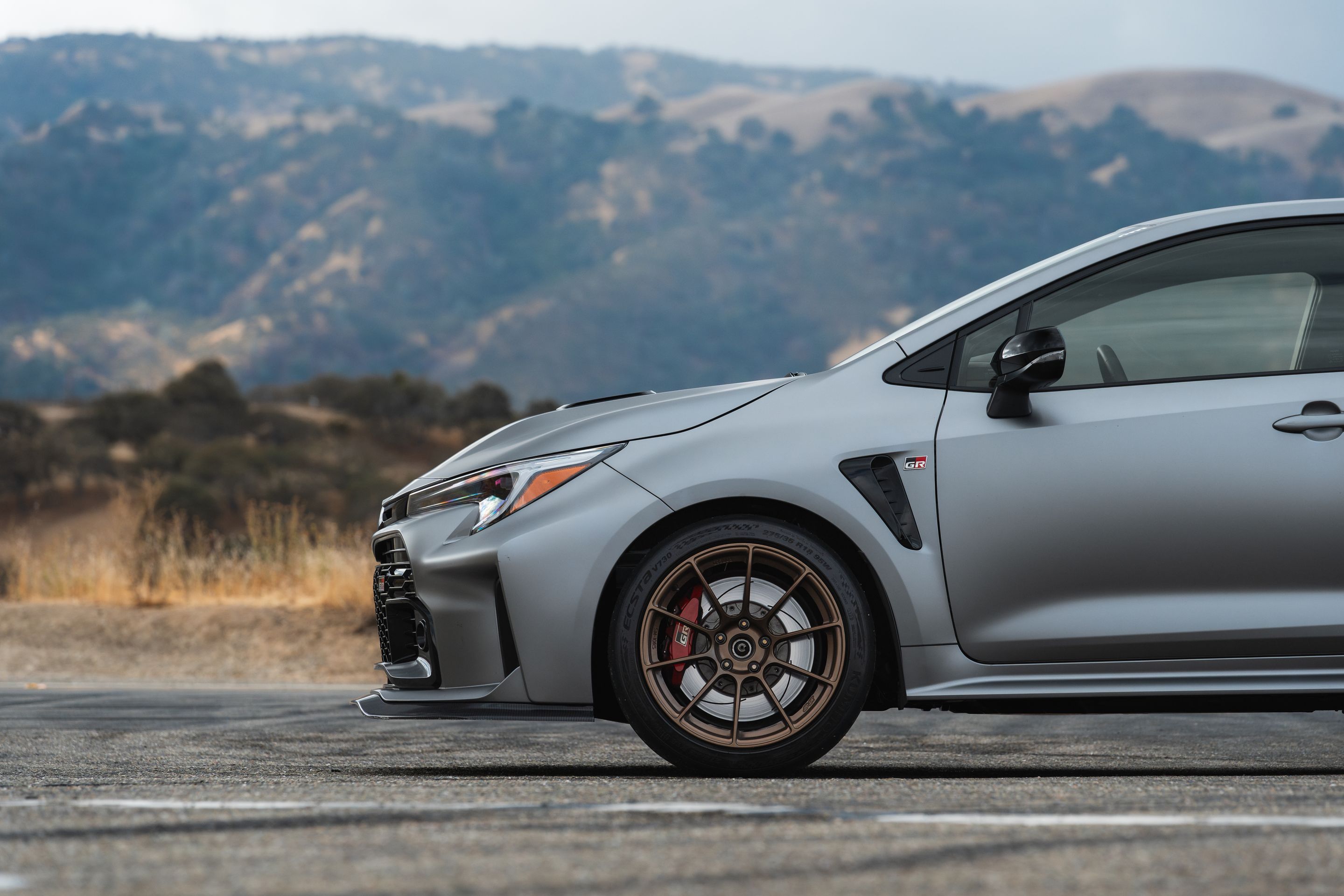 Grey Toyota GR Corolla with 18" SM-10RS Apex wheels in Satin Bronze
