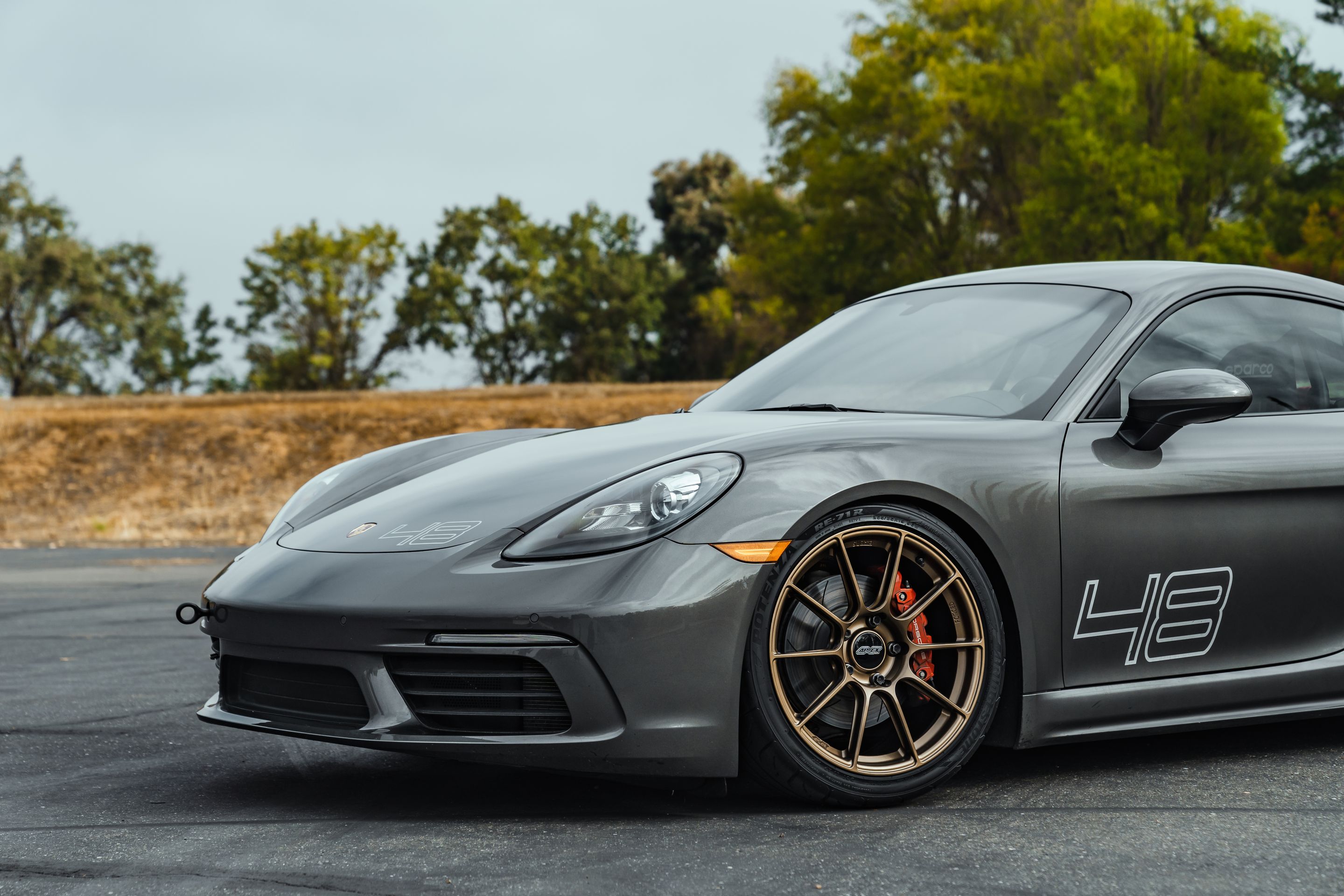 Grey Porsche 718 Cayman S with 19" SM-10RS Apex wheels in Satin Bronze