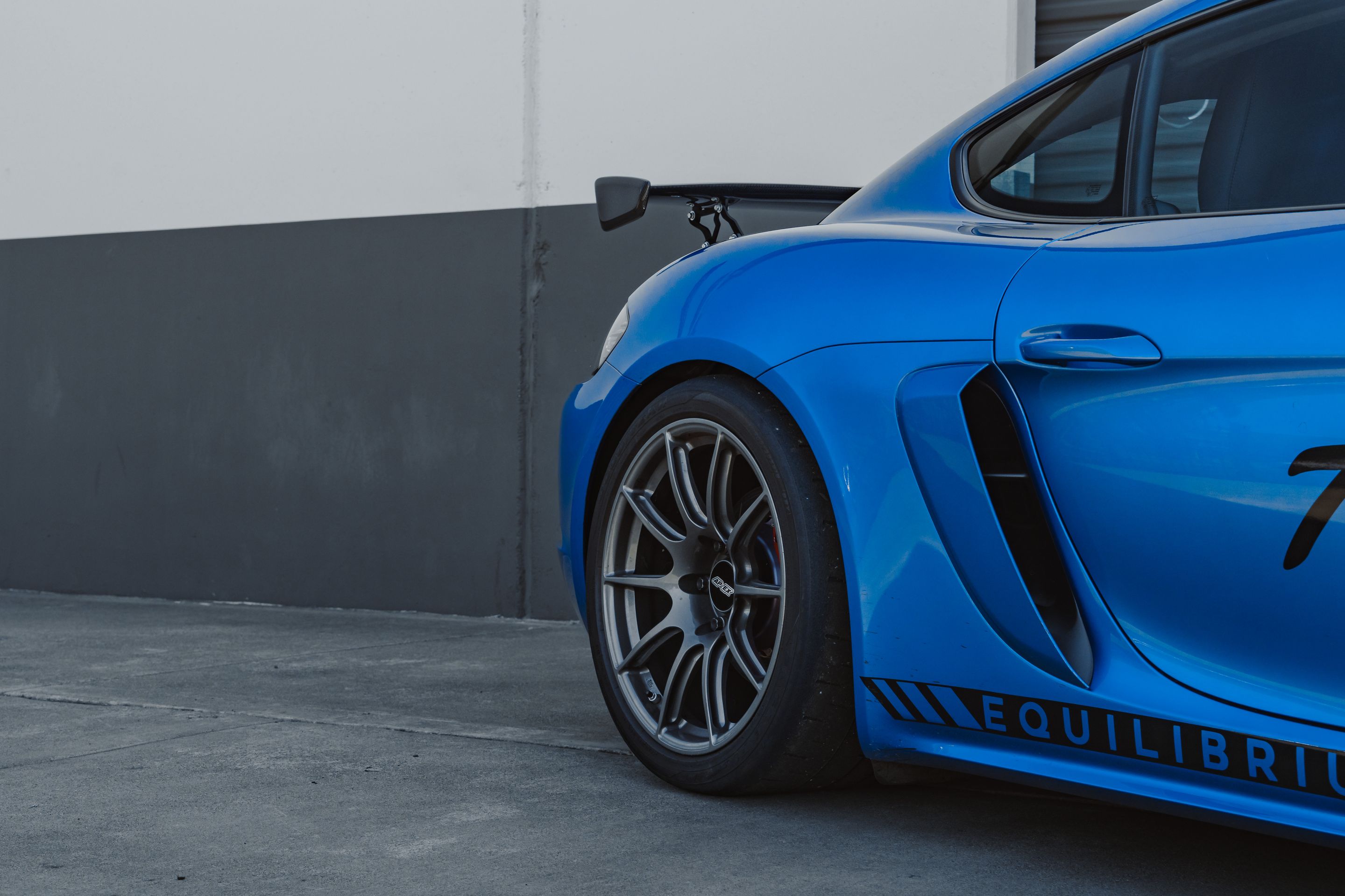 Blue Porsche 718 Cayman GTS 2.5L with 19" SM-10 Apex wheels in Anthracite