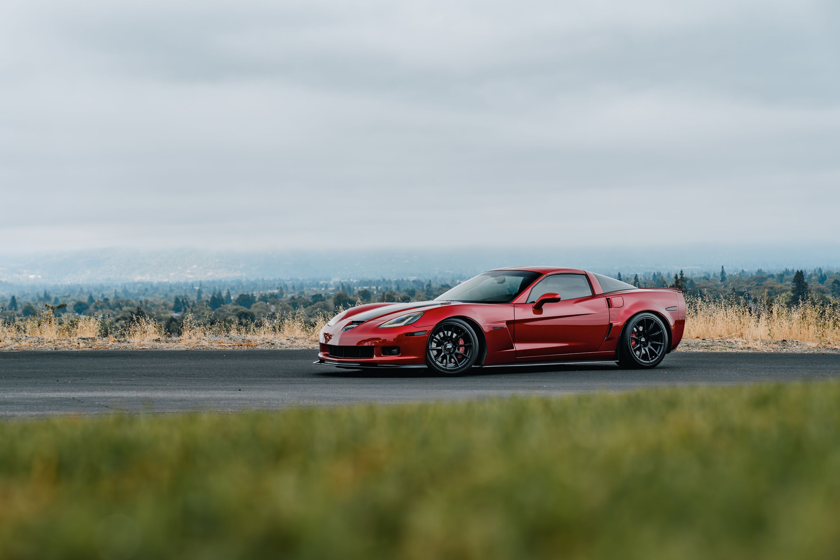Red Chevrolet C6 Corvette Z06 with 18"/19" SM-10 Apex wheels in Satin Black