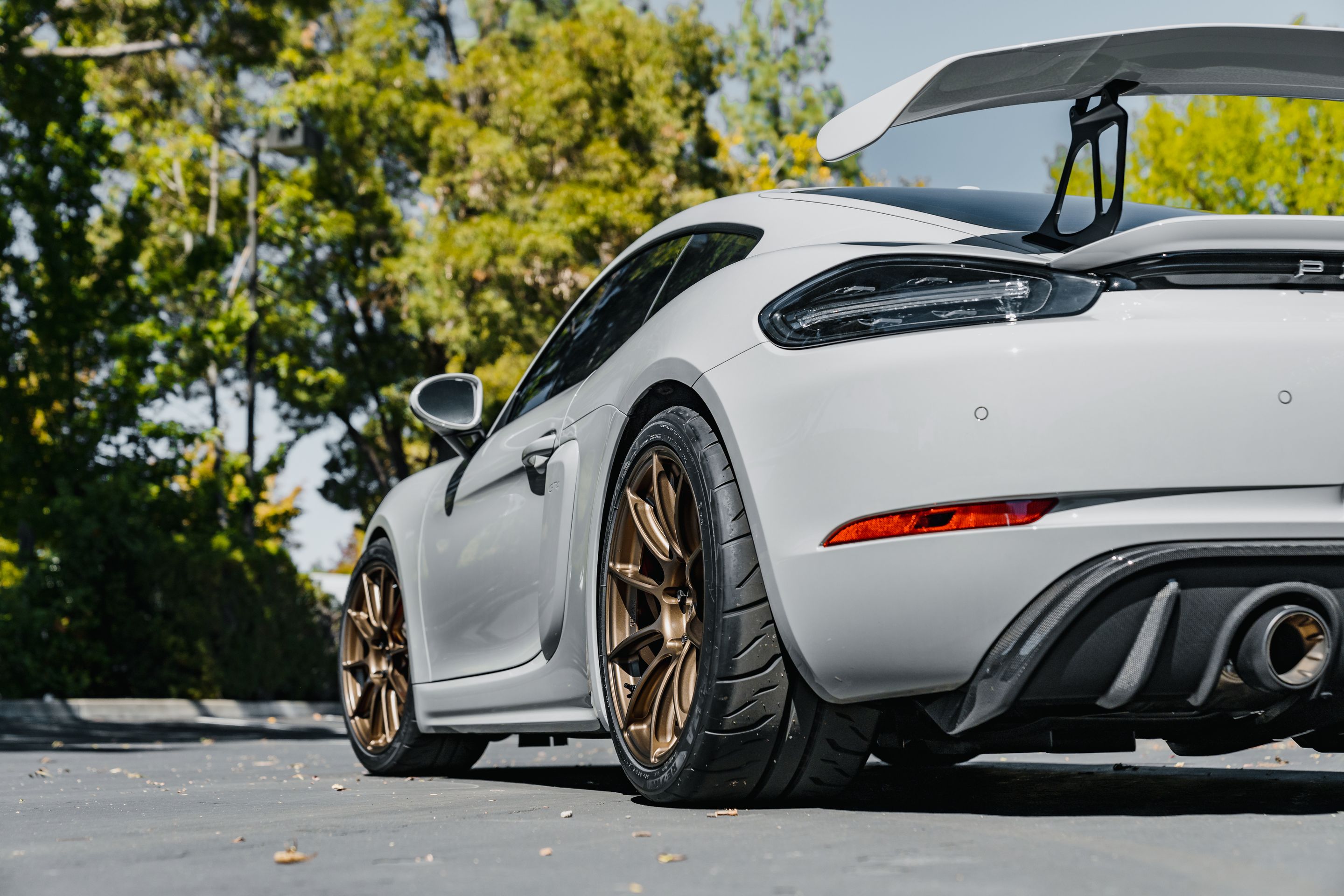 Grey Porsche 718 Cayman GT4 with 19" SM-10RS Apex wheels in Satin Bronze