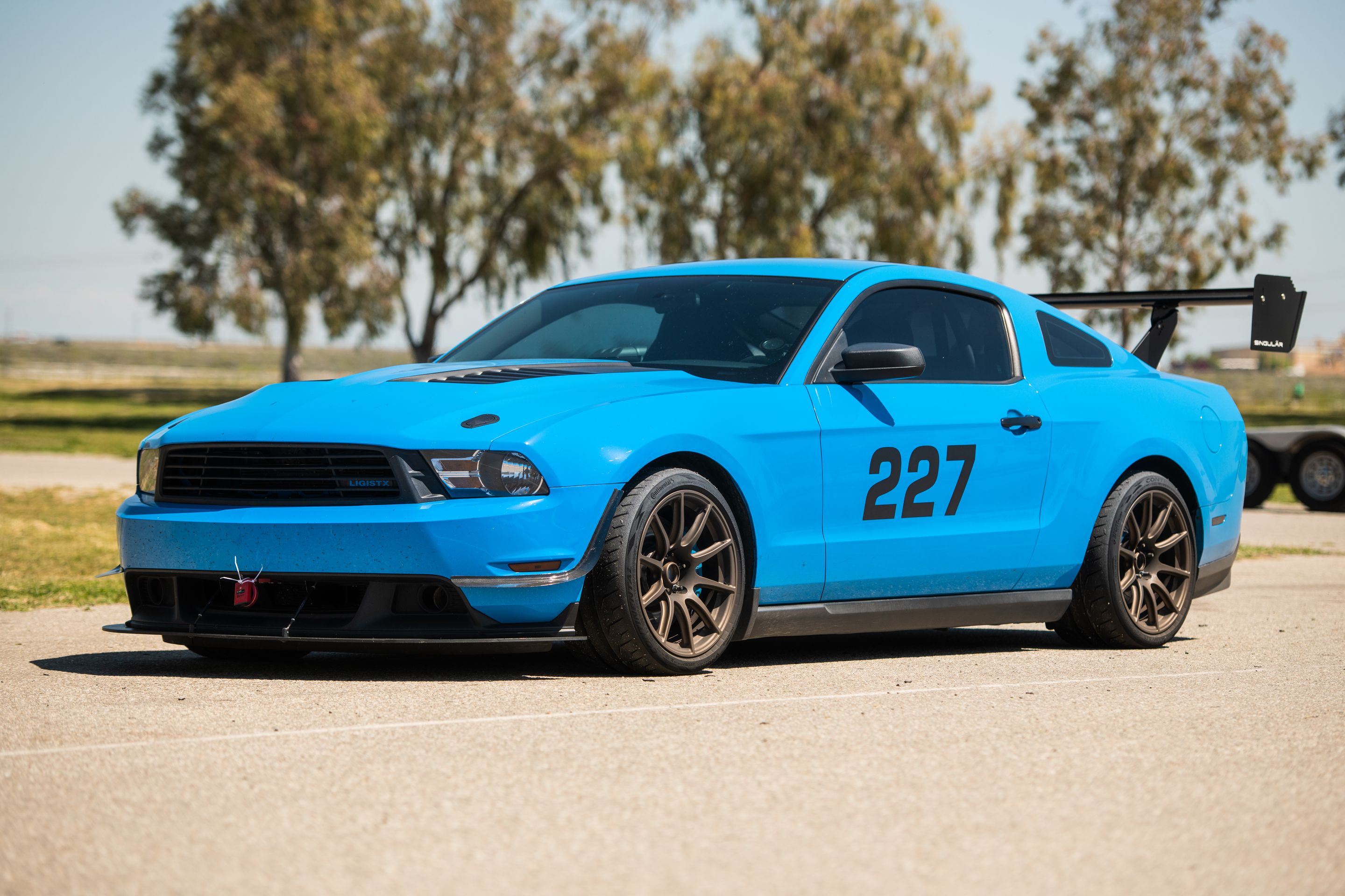 Blue Ford S197 Mustang V6 with 18" SM-10 Apex wheels in Satin Bronze
